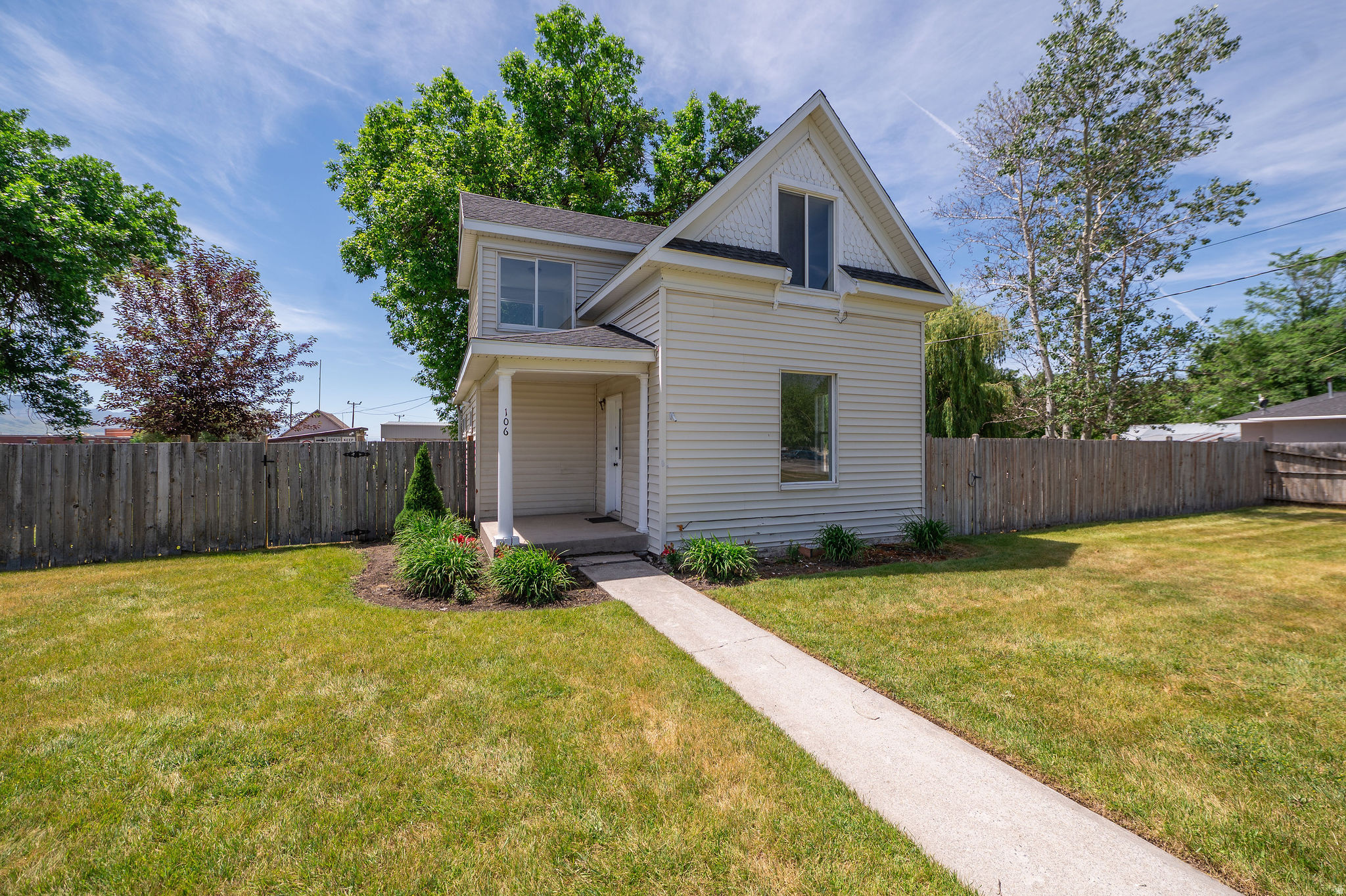 This 1900 home has been renovated well past the surface. New roof, new wiring, new plumbing, and a new A/C mean the expensive behind-the-wall systems are already handled. New flooring, interior doors, and fresh paint inside and out round out the work. The remodeled kitchen runs the main floor with quartz counters, sage green shaker cabinets with brushed gold hardware, and new stainless appliances that stay with the home. A generous family room and the full bath round out the main level, with three bedrooms upstairs. Outside is where this lot pulls ahead. A third of an acre on a corner, with mature grass, flowerbeds already in bloom, a graveled firepit area for evenings outside, and a freshly tilled garden ready to plant. Two sheds handle storage or a small workshop, and the driveway parks six with room for more along the street. Then there's the location, the one thing you can't build into another house. You're next door to Lewiston Elementary and the fairgrounds, and a block from the grocery store, gas station, library, and movie theater. Walk to all of it. It's move-in ready, with nothing left to do but unpack.