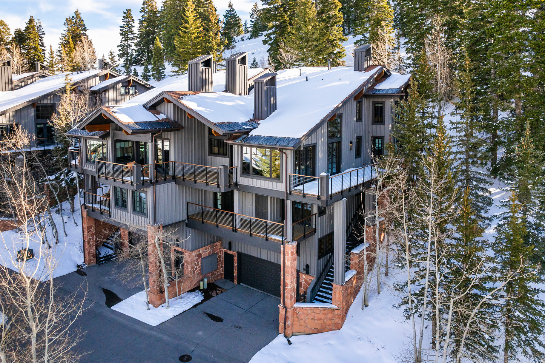 Stag Lodge #43 is a premier ski-in/ski-out residence in Deer Valley, positioned at the east end of the community where it borders open space and offers rare, unobstructed views of the surrounding mountains from nearly every window. This five-bedroom property stands out for its privacy, views, direct access to the "Success" ski run, and timeless mountain architecture. With over 4,700 square feet spread across four levels and served by an elevator, the home features vaulted ceilings, wood-burning fireplaces, multiple decks, a 1,100-bottle wine room, a dedicated ski and bike tuning workshop, a ski prep room with private trail access, and a two-car garage. A unique studio/apartment above the garage offers incredible flexibility for guests. The upper-level primary suite includes a wood-burning fireplace, generous bathroom, walk-in closet, and laundry. Owners at Stag Lodge enjoy an array of amenities including a fully staffed front desk with concierge service, ski valet, a private restaurant and lounge, heated pool and spa, fitness center, and on-call transportation. Offering a nostalgic and luxurious ski ambiance, this is a rare opportunity to secure a legacy property in one of Park City's most beloved mountain communities.