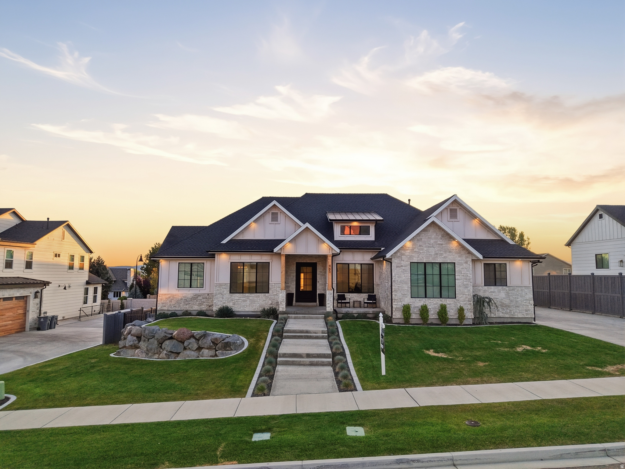This extraordinary modern craftsman masterpiece w/ lake views is designed to impress from the moment you step through the custom steel front door. Showcasing soaring 14' ceilings, oversized spaces, & impeccable high-end finishes throughout, every detail of this home was thoughtfully crafted to deliver both luxury & functionality. From the stunning 6" plank hardwood flooring to the expansive office, oversized mudroom, massive main-floor laundry room, & incredible butler's pantry complete w/ a convenient Costco door, this home offers elevated living at every turn. At the heart of the home, the chef's kitchen is a true showpiece featuring crisp white quartz countertops, a farmhouse sink, tiled backsplash, premium gas cooktop, and abundant cabinetry, all seamlessly connected to the open-concept living space. The striking linear gas fireplace set against a dramatic rock accent wall, custom built-ins, & elegant tray ceiling create a warm yet sophisticated atmosphere perfect for entertaining or everyday living. Large-format windows flood the home with natural light, while 8' doors & upgraded 6cm countertops throughout further enhance the custom luxury feel. The spacious primary suite is a private retreat designed for comfort & relaxation, offering a spa-inspired bathroom complete w/ a dual vanity, a freestanding soaking tub, oversized double-head shower, & an expansive walk-in closet. Every bedroom throughout the home is generously sized, providing exceptional space for family & guests alike. The fully finished walkout basement is equally impressive, accessed by an extra-wide 4' staircase & featuring 9' ceilings, daylight windows, a full 2nd kitchen, additional laundry room, 2 beautifully finished bathrooms, 3 additional oversized bedrooms, abundant storage space, & direct access to the backyard through sliding glass doors-making it ideal for multi-generational living, entertaining, or a potential mother-in-law setup. Step outside to your own private backyard retreat featuring a generator so you never lose power, a large two-tier covered deck, fire-pit area, basketball court, playhouse, trampoline, a charming chicken coop and it even has Solar Panels for virtually no electric bill . This one-of-a-kind property perfectly blends luxury, comfort, & lifestyle in a way that is rarely found. A truly spectacular home you will not want to miss.