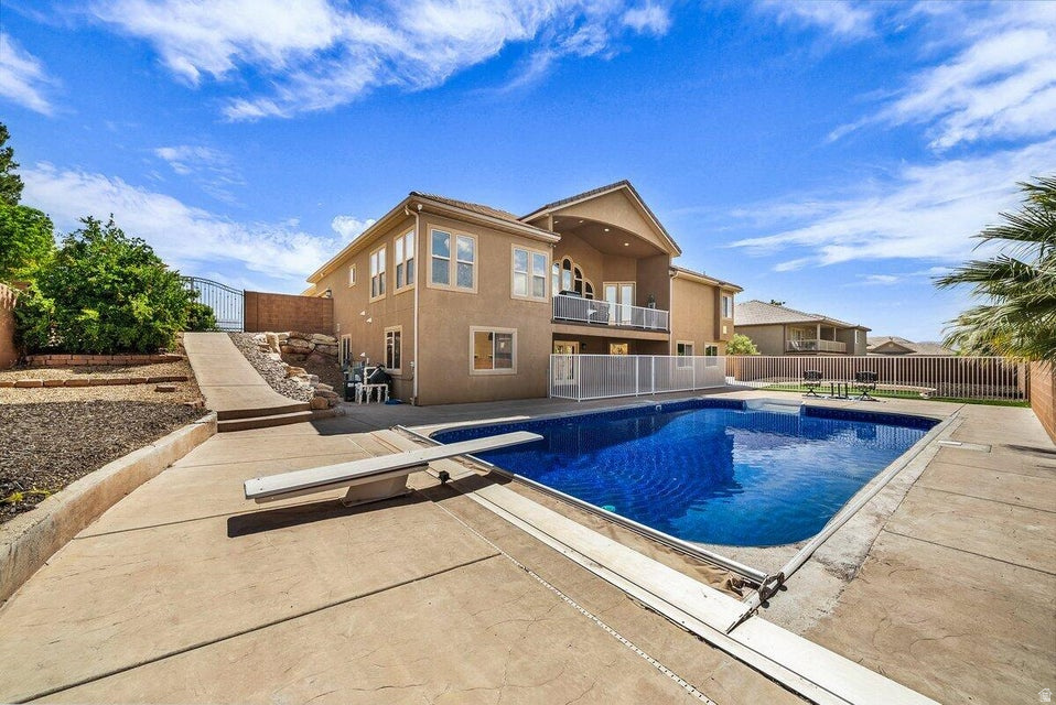 Welcome to this luxury estate located in a highly desirable St. George neighborhood, offering 7 bedrooms, 3.5 bathrooms, and an expansive 4,584 square feet of thoughtfully designed living space, all with NO HOA! The home features a spacious 3-car garage with epoxy-coated floors and built-in storage, perfect for vehicles, recreational toys, tools, and hobbies. Designed for both everyday living and entertaining, this exceptional property offers two primary suites, one on each level, ideal for multi-generational living or hosting guests with privacy and comfort. Enjoy two full kitchens, two laundry rooms (upstairs and downstairs), and two expansive living and family rooms, allowing each level to function independently. The fully finished walkout basement adds incredible versatility for additional living, office, or entertainment space. Situated on an extra-large .32-acre lot, the outdoor space is equally impressive, featuring your own private orchard with pomegranate, mulberry, peach, apricot, apple, cherry, fig, pluot, plum, and nectarine trees. The backyard also showcases a fully fenced pool approximately 35x21 in size, complete with an automatic cover and brand-new surrounding concrete, creating the perfect setting for relaxing or entertaining. Recent upgrades include premium LVP flooring throughout the entire home and stairs (no carpet), new appliances, double ovens, reflective window film on all windows for enhanced energy efficiency, and extensive built-in shelving. The home is pre-wired with Cat-6 for fast, reliable networking and equipped with a full security system, including interior and exterior cameras, for added peace of mind. Call today to schedule a private showing or learn more about this incredible home! Buyer to verify all information, deemed reliable, however buyer to verify all info including utilities, rental restrictions, and HOA information if applicable. Photos have been virtually staged using AI. Photos also include AI renderings including the firepit, pickleball court, and basketball court.
