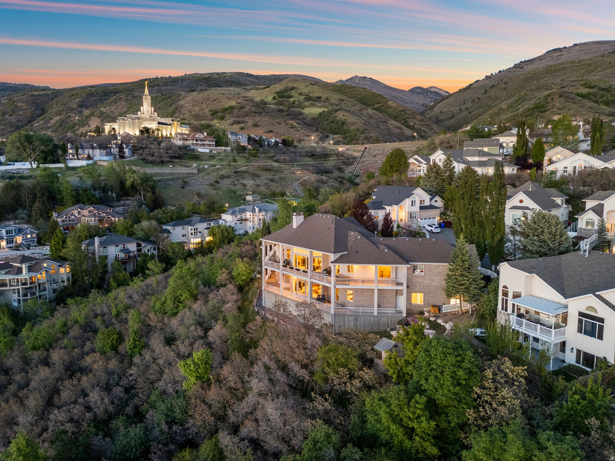 ***OPEN HOUSE - JUNE 6 - 11:00-1:00pm*** Significant Price Adjustment!! Perched on a quiet cul-de-sac with sweeping panoramic valley views and unforgettable sunsets, this exceptional 7,215 sq. ft. custom home offers luxury living at its finest. Thoughtfully designed and impeccably maintained, the residence features 6 spacious bedrooms, 2 full baths, three 3/4 baths, one 1/2 bath  blending elegance, comfort, and functionality throughout.   Grand vaulted ceilings and six beautiful fireplaces create warmth and architectural character, while expansive windows frame breathtaking views from nearly every room. The well-appointed floor plan offers generous gathering spaces, refined finishes, and an effortless flow for both everyday living and entertaining.  The luxurious primary suite is a true retreat, complete with separate his-and-her baths and walk-in closets for ultimate privacy and convenience. The full walk-out lower level includes a charming one-bedroom, one full bath apartment with its own private entrance --ideal for guests, multigenerational living, or potential rental income.  Outdoor living is equally impressive, with inviting spaces designed to enjoy the incredible sunsets, serene surroundings, and spectacular valley vistas year-round.  This rare property combines timeless craftsmanship, exceptional care, and an unbeatable setting in one extraordinary home.    Convenient access to downtown Salt Lake City and/or Salt Lake City International Airport as well close proximity to parks, schools, hiking trails along with fun shopping on Main Street in Bountiful!  HOA offers snow removal and yard care.