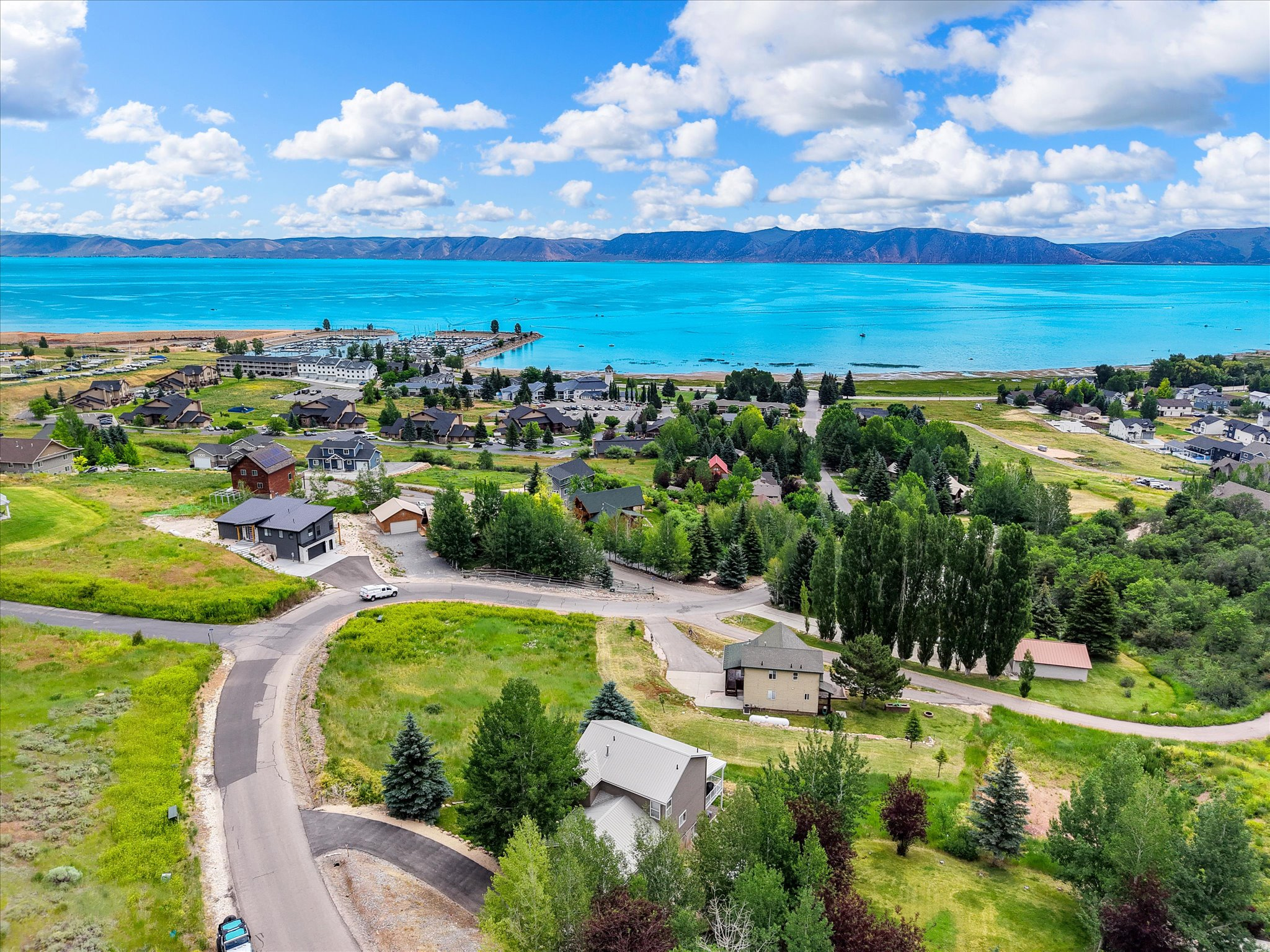 Enjoy beautiful Bear Lake views just a short walk from the marina, restaurants, shopping, and Garden City's popular bike and walking paths. This spacious 2,160 sq. ft. home features 4 bedrooms, 3.5 bathrooms, and is fully furnished and turnkey-ready for your personal enjoyment or continued use as a successful short-term rental. Designed to accommodate large groups, the home comfortably sleeps up to 18 guests (12 in beds). The spacious primary suite includes a walk-in closet and private bath, while two additional upstairs bedrooms share a convenient Jack-and-Jill bathroom, both with jetted tubs. Relax on the new Trex deck overlooking the large backyard, or step out the walk-out basement to the patio and new hot tub after a day on the lake. The open floor plan provides plenty of room for gathering. Whether you're looking for a vacation home, investment property, or both, this home offers an unbeatable location, rental potential, and everything you need to start enjoying the Bear Lake lifestyle with lake and mountain recreation galore..