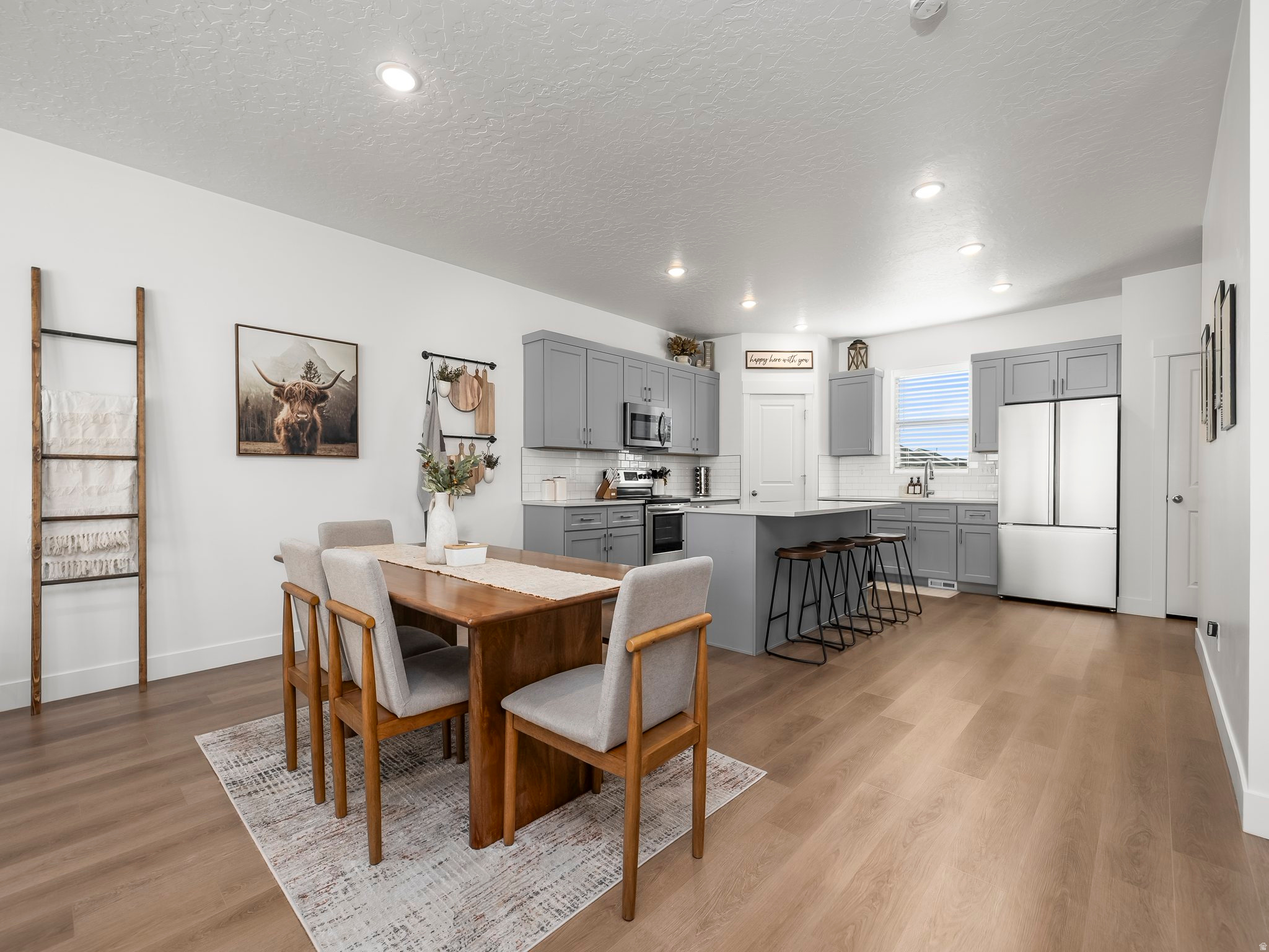 Welcome to this beautiful 3-bedroom, 2.5-bath townhome in The Towns at Brylee Farms! Built in 2024, this 2,555 sq ft home offers modern style and functionality in a thriving Eagle Mountain community. Enjoy an open floor plan with a spacious great room, large windows, and beautiful finishes throughout. The kitchen features quartz countertops, ample cabinetry, and included dishwasher, microwave, and stove. Curtain rods and curtains in the master and small bedroom are also included. The 4 car garage features a home gym, and the mounted mirrors may stay upon request. Upstairs includes a roomy primary suite with walk-in closet and private bath. The unfinished basement provides space to grow or customize. It is the perfect space to finish a mother in law apartment. Energy-efficient design with double-pane windows, central air, and forced-air heating. Community amenities include a clubhouse, pool, playground, picnic area, and pickleball and tennis courts. This home is subject to third party approval. Buyer to verify all information.