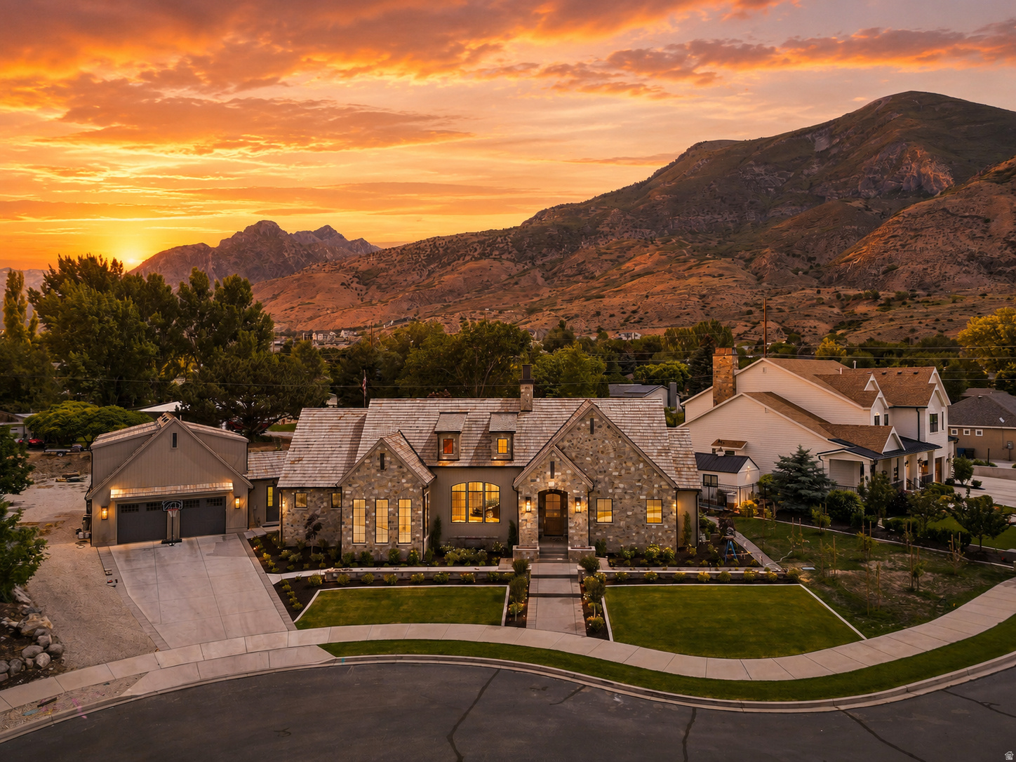 Nestled against the stunning Pleasant Grove foothills, this modern European cottage blends timeless architecture with refined, livable luxury. A stone exterior, steep gables, warm wood accents, and manicured landscaping create unforgettable curb appeal, while the surrounding mountain views provide a breathtaking backdrop. Inside, thoughtful design is found at every turn. The open main living area features soaring ceilings, rich wood detail, a beautiful stone fireplace, custom built-ins, and large windows that fill the home with natural light. The kitchen is both elegant and functional, with an oversized island, high-end finishes, a farmhouse sink, designer lighting, and a statement butlers pantry with abundant storage and custom cabinetry. The primary suite offers a peaceful retreat with a spacious bedroom, spa-inspired bath, freestanding tub, oversized glass shower, dual vanities, makeup station, and a large custom closet. Additional spaces throughout the home include built-in work areas, charming arched details, flexible gathering rooms, and beautifully finished bedrooms designed for comfort and style. The lower level expands the home's livability with a generous family room, kitchenette/wet bar, exercise space, additional bedrooms, and a playful custom bunk room. Outdoors, enjoy covered patio living, mature landscaping, garden space, and incredible mountain views-all in a quiet Pleasant Grove cup-de-sac setting close to recreation, schools, shopping, and everyday conveniences. This is a rare opportunity to own a home that feels custom, warm, elevated, and truly unforgettable.
