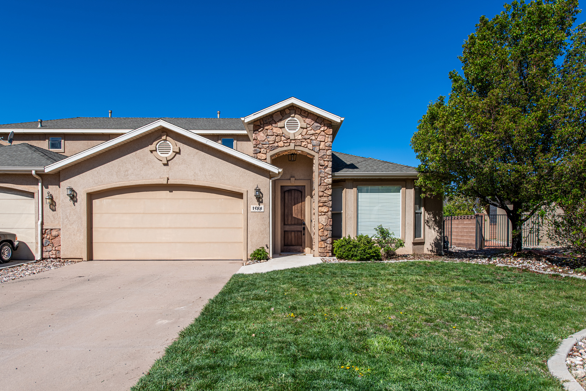 Beautifully maintained Cedar City twin home in Cedar Mountain Villas offering 3 bedrooms, 2.5 bathrooms, and a functional two-level layout with the primary suite on the main floor. This move-in-ready home features an open-concept kitchen with rich, solid wood cabinetry, extra bar seating, matching stainless steel appliances, generous prep space, and easy flow into the dining and living areas.  Enjoy the colder evenings with the cozy fireplace. The spacious primary suite includes a relaxing jetted tub, a separate shower, and a walk-in closet. Upstairs, large bedrooms provide flexibility for guests, family, or office space, and have wood built-in organizers. Brand new water heater and front porch light fixture.  Enjoy the covered patio, complete with new concrete and nice sunshades. The backyard is landscaped with brand new beautiful xeriscaping. The attached 2-car garage stands out with a unique upgraded auto shop-quality garage floor (Swiss Trax) offering a clean, polished, and highly functional space unlike any other garage in town. Conveniently located near trailheads, parks, schools, shopping, and everyday amenities, this property combines comfort, practicality, and easy living in Cedar City. The owner currently has a month-to-month leased tenant who would like to remain if possible, but undertands its based on the new owner's preference. Ideal for an investor OR a new home owner who wouldn't have to wait out a lengthy lease on an occupying tenant. In summary, this home offers 3 bedrooms, 2.5 baths, 1,848 sq ft, a 0.14-acre lot, an attached 2-car garage, and was built in 2006. Most furniture and some decor included!