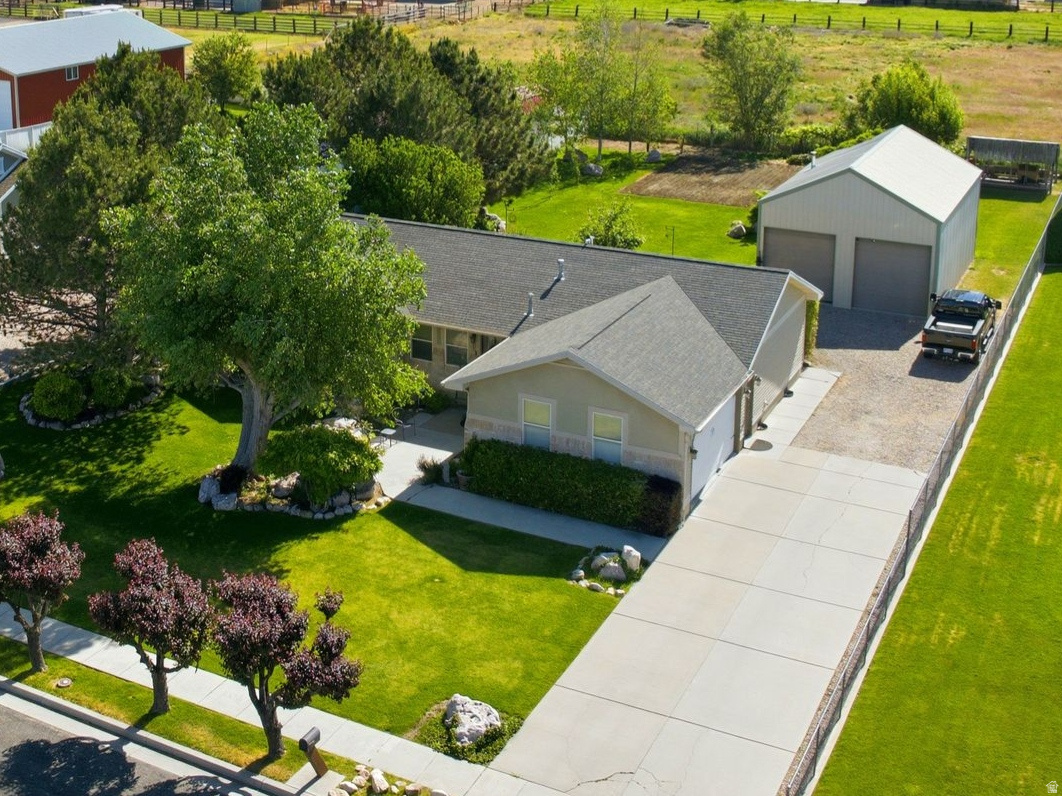 Enjoy the peace and privacy of country living without sacrificing convenience. Situated on a spacious half-acre lot in Plain City, this well-maintained single-level home offers stunning mountain views, no backyard neighbors, and a quiet setting. The property features a large patio, mature landscaping, a garden area, RV parking, a two-car garage, and plenty of room to enjoy the outdoors.  A standout feature of the property is the 24' x 36' detached workshop, offering endless possibilities for hobbies, storage, workspace needs, or additional vehicle parking. With close proximity to everyday amenities, this property offers a rare combination of rural charm, functionality, and convenience.  Square footage figures are provided as a courtesy estimate only and were obtained from county records.  Buyer is advised to obtain an independent measurement.