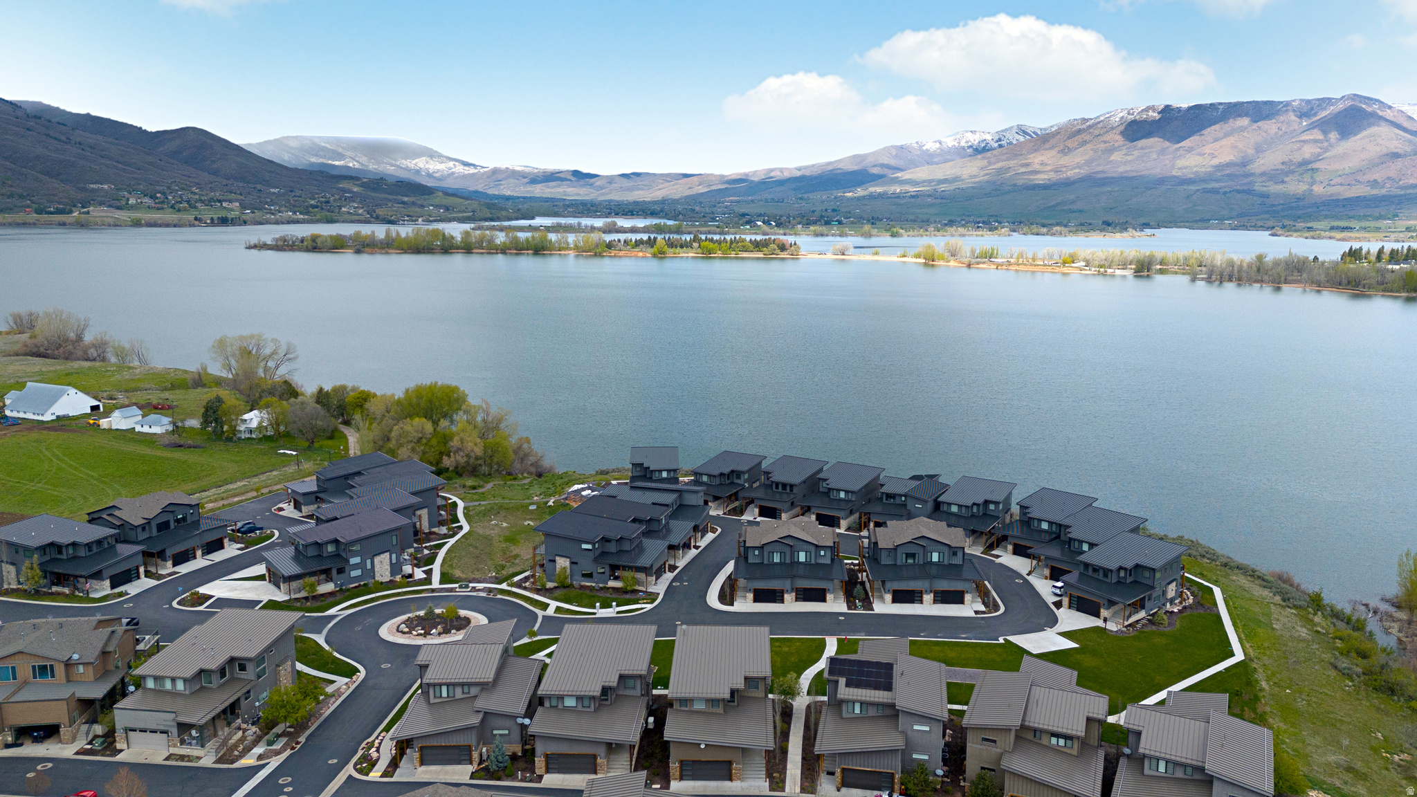 Extraordinary Luxury Lake Home nestled in the heart of the Wasatch Mountains and overlooking Pineview Reservoir and ONLY 8 minutes to world class skiing at Snowbasin Ski Resort, home to the 2034 Winter Olympics, and 25 minutes to Powder Mountain Ski Resort, under 1 hour to SLC and the SLC Airport. Experience the stunning lake and mountain views through expansive windows, flooding the home with natural light, seamlessly blending indoor and outdoor living. The open-concept layout features a well appointed kitchen with oversized island, ample dining space, large greatroom with inviting stone fireplace creating an inviting yet luxurious space. Sliding glass doors extend the living space to a covered deck overlooking the water to enjoy solace, evening sunsets and gathering with friends and family. Upstairs, the spacious primary suite showcases incredible panoramic views, a private deck, spa-like grand bath with elegant finishes and glass-enclosed shower. Two additional upstairs ensuite bedrooms with private baths are thoughtfully designed for comfort, privacy and style. The lower level feature, large, open family room with cozy fireplace, a wet bar, sliding doors to covered patio, private guest suite and bathroom. Well designed laundry and mudroom and finished garage. GATED community. HUGE BONUS Separate 14'X40' DETACHED GARAGE Unit S5 for sale for additional $175,000 (tax id: 20-174-0020) PERFECT for Boat or RV storage. ALSO all furniture/furnishings excluding main level couch are available for purchase. Zoned for short term rentals, making this property an excellent investment opportunity.