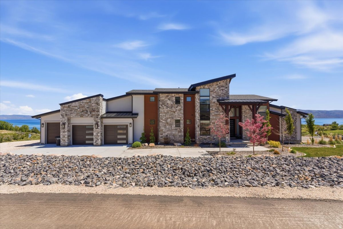 Spacious newer construction Bear Lake retreat with panoramic lake views, designed for large gatherings, multi-generational living, or vacation rental use. This 8-bedroom, 6-bath property offers over-the-top functionality with three private suites, two full kitchens, multiple gathering spaces, and expansive lake-facing decks ideal for entertaining and enjoying the scenery.  Interior features include smart home upgrades with U by Moen smart showers in three suite bathrooms, oversized living areas, abundant sleeping accommodations, and thoughtfully designed spaces throughout all three levels. The flexible floor plan includes loft, main-level, and basement living areas with room to accommodate large groups comfortably. As a rental, the home can accommodate/sleep up to 34 people.   The property features two fully equipped kitchens, two spacious family rooms, large covered and uncovered deck areas, and a private 7-person hot tub positioned to capture the lake and mountain views. Outdoor amenities include a private pickleball court, ample parking for up to 16 vehicles, and two RV pads with full utility hookups including water, sewer, and power.  Located in the highly desirable Bear Lake area, this property offers easy access to boating, ATV trails, hiking, snowmobiling, restaurants, and year-round recreation. Ideal as a primary residence, second home, corporate retreat property, or investment opportunity with strong appeal for vacation use and large-group accommodations.  There are plans and the space for an additional garage and ADU to be added to the property.  Seller has plans.