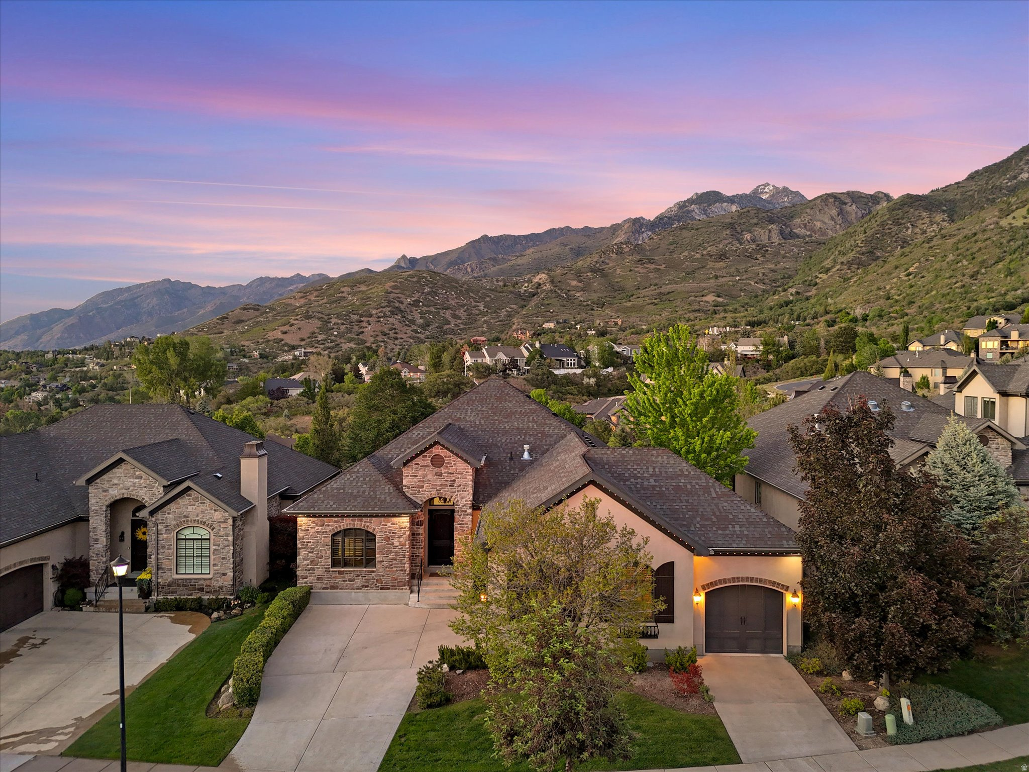 Single-level living on two levels in the highly sought after Pepperwood Creek gated community. This private, friendly, and secure neighborhood offers unmatched convenience with nearby hiking and biking trails, and is just minutes from four of Salt Lake City's premier ski resorts: Alta Ski Area, Snowbird, Solitude Mountain Resort, and Brighton Resort. Less than an hour to Park City and Deer Valley Resort, and just minutes from I-215 for quick access to downtown Salt Lake City and the airport. Backing to a protected wildlife preserve with sweeping mountain and valley views, this beautifully crafted home offers rare privacy, openness, and natural surroundings within an exclusive gated community. From the moment you enter, you'll be impressed by the grand tile entry, stunning wood finishes, beautifully refinished hardwood floors, soaring ceilings, and bright open feel. The elegant main floor office features gorgeous custom built-in cabinetry, creating the perfect workspace or library retreat. The open concept floor plan is ideal for both entertaining and everyday living. The spacious great room showcases a beautiful stone gas fireplace, plantation shutters, and a perfectly fitted entertainment center that is included with the home. The chef's kitchen features rich wood cabinetry, granite countertops, stainless steel appliances including a gas range and double ovens, a newer oversized single basin sink with premium accessories, and an enormous walk-in pantry. The adjoining dining area easily accommodates large gatherings, while the adjacent patio invites you to relax, dine outdoors, and enjoy breathtaking mountain and valley views in your own private nature setting. The luxurious main level owner's suite is generously sized and perfectly positioned to capture serene preserve and mountain views. The spa like en-suite bathroom includes dual vanities, a separate soaking tub and shower, and double large walk-in closets. A main floor laundry room completes the convenience of true single level living. What makes this home truly exceptional is that the lower level also functions as a complete single level living space, and the newly installed elevator makes access effortless without the need for stairs. The basement features a second beautifully appointed kitchen, a spacious open concept family room with built-in entertainment center and bookcases, and a second oversized owner's suite with en-suite bath, walk-in closet, and private laundry area. The included washer and dryer add even more convenience. Two additional spacious bedrooms complete the lower level, including one currently configured as a workshop that could easily be converted back to a bedroom. A massive storage area provides ample space for organization and seasonal items. The fully finished 3 car garage features an epoxy floor and two 220V outlets ready for EV charging or workshop needs. Additional upgrades and highlights include newer furnaces and water heater, a newly installed elevator, and JellyFish permanent exterior lighting for year round ambiance and holiday dcor. Residents enjoy 24-hour gated security along with exceptional community amenities including a clubhouse, swimming pool, fitness center, and HOA maintained landscaping and snow removal for truly low maintenance living.