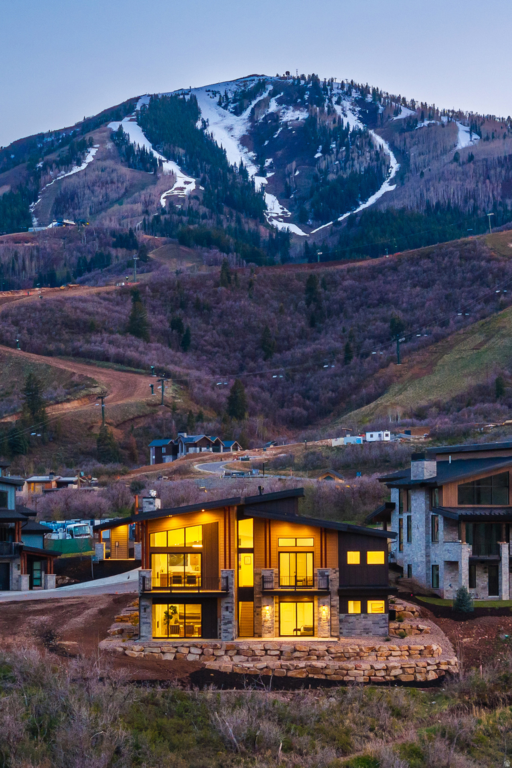 Introducing the Residences at Keetly Ridge: A Park City offering defined by access, proximity, and year-round ease of living. Positioned just minutes from Deer Valley East Village and the broader Park City core, this residence places owners at the center of one of the West's most dynamic four-season destinations. Direct ski access is streamlined with a dedicated shuttle to the lift base, allowing for efficient mornings on the mountain without the friction of in-town congestion. Beyond winter, the location continues to deliver- offering immediate connectivity to trails, open space, and the recreational rhythm that defines Park City living. Midway/Heber Valley and Historic Main Street remain just a short drive away, creating a seamless extension of dining, shopping, and lifestyle experiences. The home is designed to mirror that same sense of ease. A main-level primary suite supports true single-level living, while the open-concept kitchen, dining, and great room serve as a natural gathering point- refined, functional, and without excess. Multiple outdoor patios extend the living experience, integrating indoor and outdoor spaces throughout the warmer seasons. The lower level introduces four additional bedrooms and a secondary living area, offering thoughtful separation for guests or extended family. Whether hosting or accommodating multi-generational living, the layout maintains both privacy and flow. A Park City- aligned property for buyers who prioritize immediate access to the mountain, proximity to the core, and a lifestyle that transitions effortlessly across seasons.