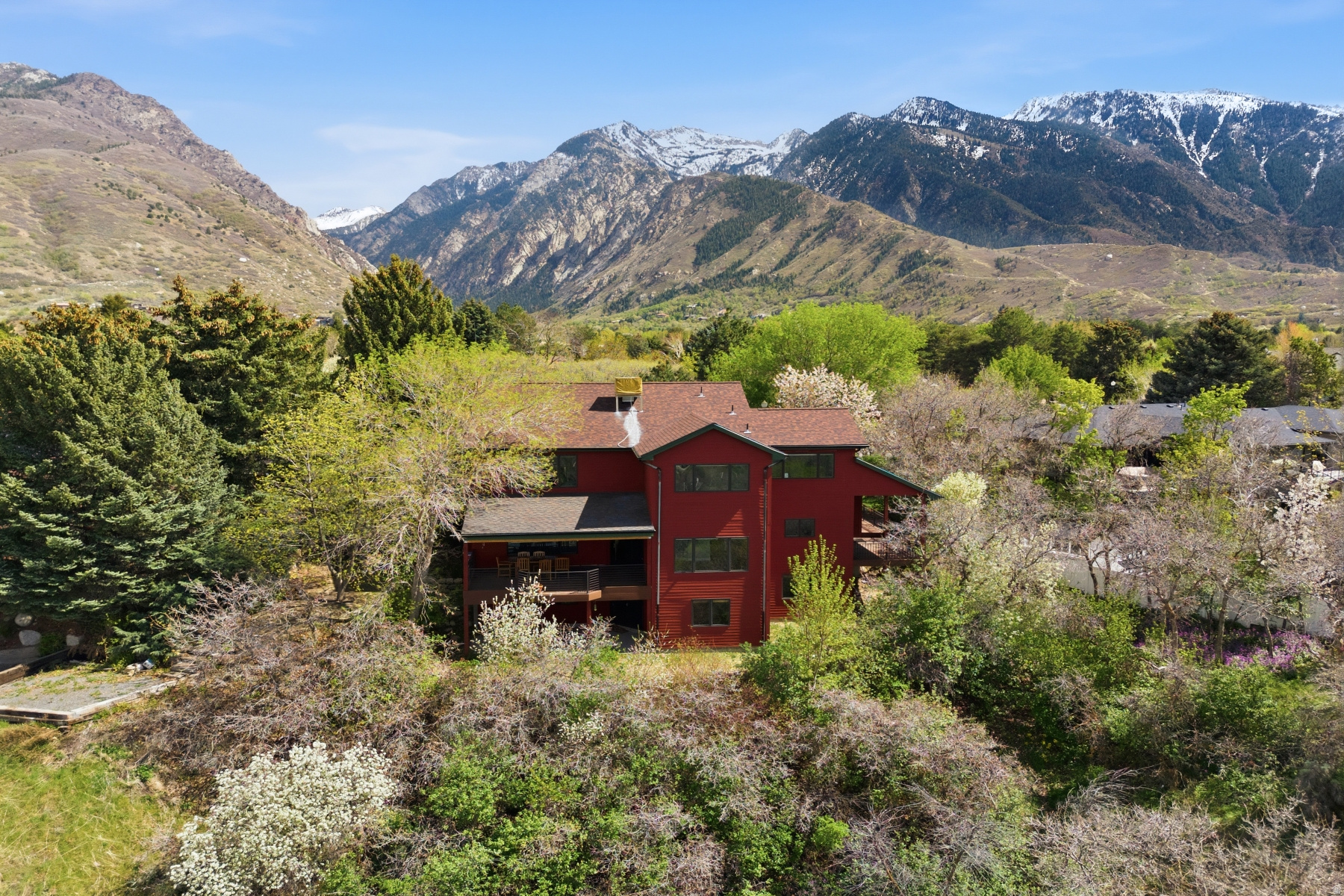 Tucked away on a quiet semi-private lane at the breathtaking mouth of Little Cottonwood Canyon, this exceptional 5-bedroom, 4- bathroom home offers the perfect blend of luxury, comfort, and unforgettable views. From the moment you step inside, you'll be captivated by the warm elegance of rich cherry cabinetry, granite countertops, stainless steel appliances, and beautiful wood flooring that flows throughout the home. The thoughtfully designed main level features a semi-formal dining area, a hidden pantry, main floor laundry, mudroom, and a private office, ideal for both everyday living and entertaining. The stunning great room is the heart of the home, showcasing built-in cabinetry, a cozy gas fireplace, and floor-to-ceiling windows that frame sweeping valley and city views. Step outside to multiple private decks, perfect for relaxing or hosting while soaking in the incredible scenery. Upstairs, the spacious primary suite offers a peaceful retreat with a walk-in closet and a luxurious en-suite bath featuring a separate tub and shower. Two additional bedrooms and a convenient Jack-and-Jill bathroom complete the upper level. The fully finished daylight basement expands your living space with a large family/media room, kitchenette, full walkout access to a private patio, two additional bedrooms, a 3/4 bathroom, and abundant storage. Outside, enjoy a beautifully landscaped yard with mature trees and a serene sitting area overlooking the valley, your own private escape. Perfectly located just 9 miles from Alta and Snowbird ski resorts, this home offers year-round recreation with hiking and biking trails right out your back door along Little Cottonwood Creek. Step outside and unwind in your private outdoor space, complete with a perfect setting for a hot tub overlooking the valley and city lights below. Additional highlights include a spacious 3-car garage, solar system, ample storage, and top-rated schools. This home truly has it all. A rare opportunity you won't want to miss!