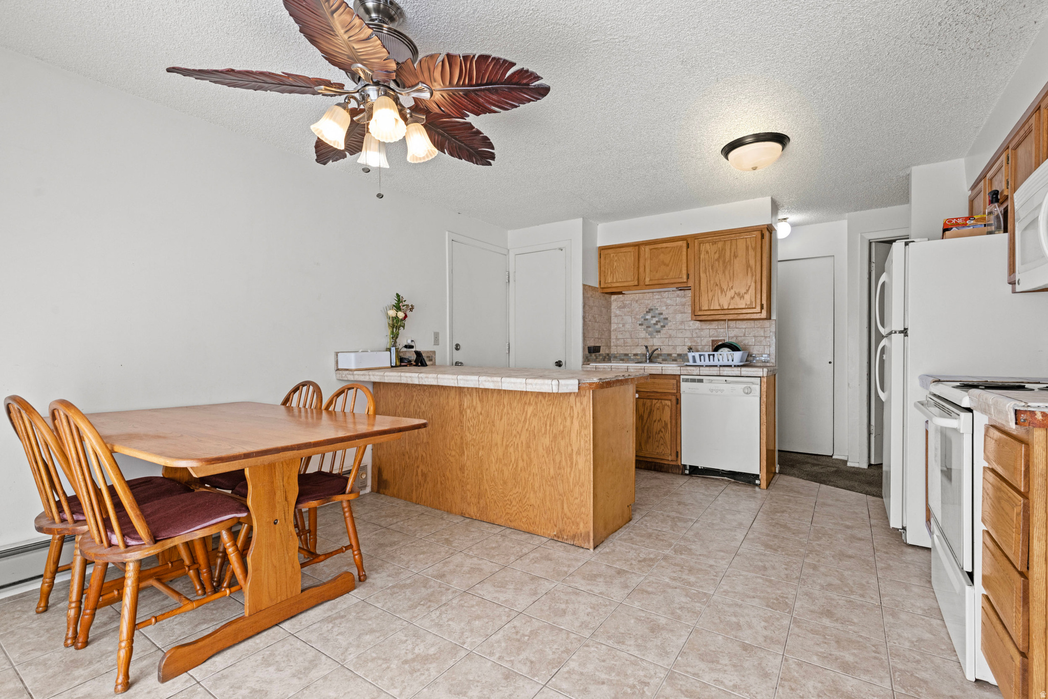 Affordable end-unit townhome in a fantastic location with easy access to I-15, Hill Air Force Base, Weber State Layton campus, shopping, and restaurants. This 3-bedroom, 3-bath home features a half bath and attached single-car garage on the main level. Upstairs offers two bedrooms, a full bath, laundry room, and a private vanity with sink in the primary bedroom. The finished basement includes a third bedroom, 3/4 bath, and stackable laundry hookups. Enjoy the fenced front patio, community pool, clubhouse, and optional monthly RV parking. HOA covers water, sewer, trash, snow removal, and pool. Refrigerator, washer, and dryer INCLUDED! All buyers welcome.