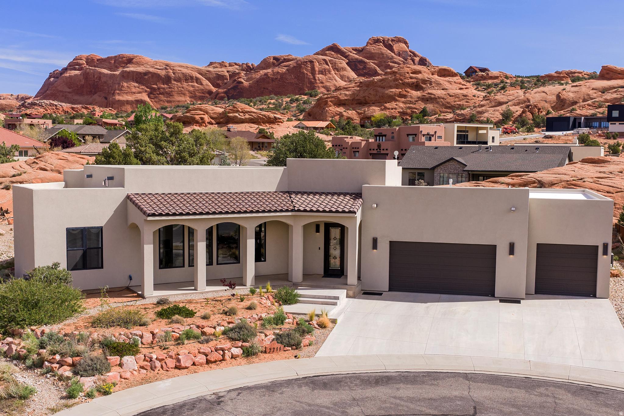 STUNNING MODERN LUXURY LIVING with panoramic views from the ROOF TOP DECK. Tucked in a quiet cul-de-sac among towering red rocks, this spectacular property includes a giant red rock formation right on the property providing natural privacy. It features multiple patio, decks and covered front veranda for ultimate outdoor living. This beautiful home was designed with comfort and views in mind. Every room commands a view of the towering red rocks and the iconic Moab Rim. The floor plan flows seamlessly through the light-filled rooms with soaring ceilings, gas fireplace, large Anderson Black on Black 100 series windows and Pella Metal Clad French Doors. The kitchen is a chef's dream with expansive white oak cabinets, Quartz countertops, 5 burner gas stove plus wall oven, and a massive 9' x 5' island. Convenient to the kitchen is a huge pantry with built-in shelves for all your storage needs. The primary bedroom features large windows and french doors for easy access to the back patio. The en-suite bath is luxurious with porcelain walk in shower, soaking tub with chandelier and extensive Quartz counter with dual undermount sinks. With 3 more spacious bedrooms, there is plenty of room to comfortably accommodate all your guests. The oversized 3-car garage provides room for all your vehicles and Moab toys. From the elevated patio in the red rocks to the amazing roof top Duradeck set up with power, lighting, gas stub and hose bib, this property has the ultimate setting for rooftop entertainment, sunset viewing, star gazing and soaking in the incredible views. All info is deemed to be reliable, but buyer to verify all.