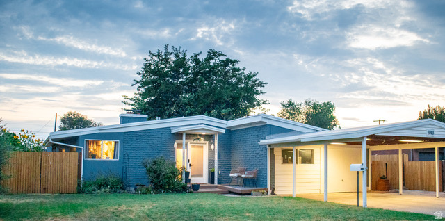 Beautiful mid-century weeping mortar rambler located in North Rose Park, offering the perfect blend of timeless design, comfort, and convenience. This light-filled, single-level home features soaring vaulted ceilings with exposed beams, creating an open and airy atmosphere. Large windows provide an abundance of natural light, the inviting sun room provides the perfect space to relax year-round while the main room fireplace is the perfect cozy spot for those chilly days. Designed for everyday living and entertaining, the kitchen features a tapas-style counter ideal for casual dining, serving appetizers, or gathering with family and friends. With four spacious bedrooms and abundant storage throughout, there's room for everyone and everything.  Step outside to your own private backyard oasis. The fully fenced yard is a true retreat, shaded by mature trees and thoughtfully designed for relaxing and entertaining. Enjoy evenings around a firepit, unwind beneath the pergola, or dine al fresco on the spacious patio. Green thumbs will appreciate the established garden boxes, mature grape vines, and countless berry bushes that create a productive and picturesque landscape. An attached garage and large storage shed provide even more space for vehicles, hobbies, and outdoor gear. Ideally situated with quick access to Salt Lake International Airport, downtown Salt Lake City's vibrant dining and nightlife scene, and major sporting and entertainment venues, this North Rose Park gem combines iconic mid-century style with modern convenience in an unbeatable location. If you've been searching for easy single-level living with authentic mid-century character and an incredible outdoor sanctuary, this home is one you won't want to miss.
