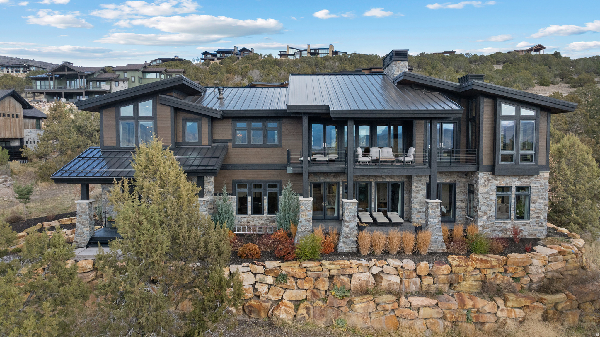 This custom-built modern home is located in a quiet, private area of the Red Ledges gated golf community, designed to take full advantage of the stunning Heber Valley, Mount Timpanogos, and Wasatch Back views. The home combines quality craftsmanship with functional design. Features include an elevator for easy access to all floors, custom metalwork by Finch Welding and Fabrication, Inc., Restoration Hardware lighting and furniture, and thoughtful finishes throughout. The gourmet kitchen is equipped with Sub-Zero refrigeration, Wolf ovens (steam, convection, and microwave), ASKO dishwashers, a Scotsman pebble ice maker, and a butler's pantry for extra prep and storage space.The layout offers a primary suite, two en-suite guest rooms, along with multiple living areas for entertaining or relaxing. The second level includes a wet bar and theater room.  Lower level has a large flex room ideal for a gym or golf simulator. Outdoor living is a highlight, with four covered decks that provide plenty of space to enjoy the mountain setting. The driveway has radiant heat piping installed (just needs to be connected), and the garage is wired for an electric vehicle charger. With space for over seven vehicles, there's plenty of room for storage or a car collection. Furniture and hot tub are negotiable. Ownership at Red Ledges includes access to world-class amenities-golf, fitness, tennis, pickleball, swimming, and dining-all within a secure, gated community. No need to be on a wait list, Golf or Lifestyle Membership are available, subject to Club membership guidelines. Buyer and Buyer's Broker to verify all information including square footage and acreage