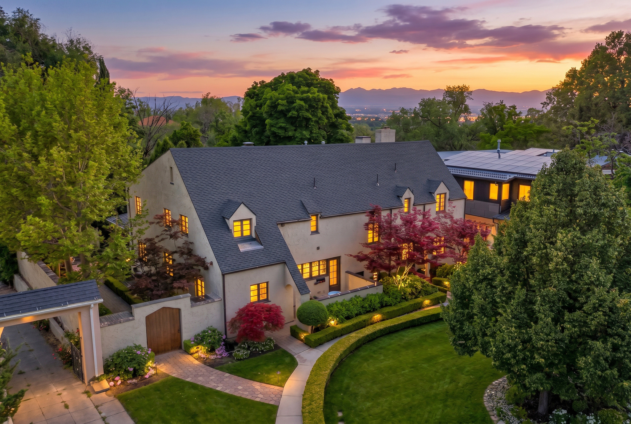 Timeless architecture, thoughtful modernization, and an extraordinary natural setting come together in this 6,444 sq. ft. home perched above Red Butte Creek on a .38-acre lot. Originally built in 1923 and meticulously remodeled with a new primary suite, family room, kitchen and a further kitchen renovation and breakfast room addition, this residence blends classic character with smart and functional design. Enjoy uncommon privacy with no rear neighbor on Harvard and a serene, tree-filled backdrop. Multiple terraces, patios, and an outdoor fireplace create a seamless indooroutdoor lifestyle and capitalize on the peaceful, green setting just minutes from Downtown SLC, U of U, and Westminster University. Rich hardwood and stone floors, exposed beams, and marble countertops anchor a refined and comfortable aesthetic. The main level centers around an inviting entry and hall leading to a sophisticated library with a fireplace, a large living room with a fireplace that opens to a spacious covered terrace, and a warm family room with a fireplace that flows to an open terrace. The beautifully updated kitchen and adjoining sunroom are designed for both everyday ease and entertaining, complemented by a dining room and well-appointed butler's pantry / laundry and food pantry combination. A convenient powder room serves the main floor living spaces. The upper level hosts a generous primary suite with his-and-hers closets, offering a private retreat above the treetops. A secondary en suite bedroom provides comfort for guests or family, while two additional bedrooms share a three quarter bathroom, optimizing functionality.  On the lower level, flexible spaces accommodate a range of lifestyles: a comfortable family room, an en suite daylight bedroom with exterior access ideal for guests, a dedicated sewing room, audio visual room and ample storage. The 2-car attached garage includes a pull-through third parking spot behind the home. This home is a true showstopper with its blend of historic charm and elegant finishes to its layered outdoor spaces and quiet, wooded surroundings above Red Butte Creek. Do not miss this opportunity!