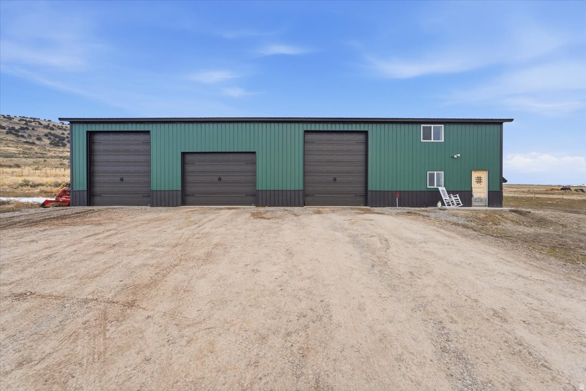 Set on over 40 acres of wide-open land, this property delivers privacy, views, and the freedom to live life on your own terms. Designed for those who value space, utility, and self-sufficiency, this property offers a rare blend of rural living with modern infrastructure already in place. The 10-car garage setup is a standout feature. A massive open gravel garage accommodates up to eight vehicles, while the heated, thermostatically controlled area, functions as a true workspace or optional two-car enclosed garage, bringing the total capacity to ten. Whether you're storing equipment, toys, or building something of your own, this setup is built to perform. The residence includes 2,000 square feet of living space, thoughtfully laid out over two levels. The main floor features a mudroom, kitchen, bedroom, and bathroom perfect for everyday living. Upstairs you'll find laundry, a bunkhouse-style sleeping area, and a second bathroom, making the space functional and flexible for family, guests, or recreational use. Infrastructure is dialed in with 400-amp service to the transformer and 200-amp service to the building, along with culinary water, electric, and propane. Outdoors, the land is already working for you with a fenced horse corral, chicken coop area, and approximately eight acres of dry farm ground. Surrounded by expansive views and natural beauty, this property offers true seclusion and the opportunity to live a private, rural, self-sustaining lifestyle without sacrificing comfort or capability. A rare opportunity to own land that's ready to support the way you want to live.