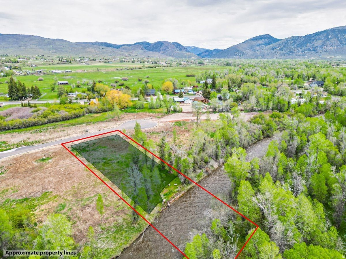 Experience the rare opportunity to own the last remaining ready-to-build riverfront lot in the simple and quaint neighborhood of River Haven. This exceptional homesite offers breathtaking mountain views, a generous flat building envelope, and the perfect blend of luxury living and peaceful country charm. Included in the price are fully designed and approved plans for a stunning 4,582-square-foot custom home featuring a spacious 4-car garage-allowing you to fast-track bringing your dream home to life. Mature trees create a serene natural setting while all utilities are conveniently stubbed to the lot, including city water, city sewer, natural gas, power, and All West high speed fiber. The serenity of the Weber River awaits you...