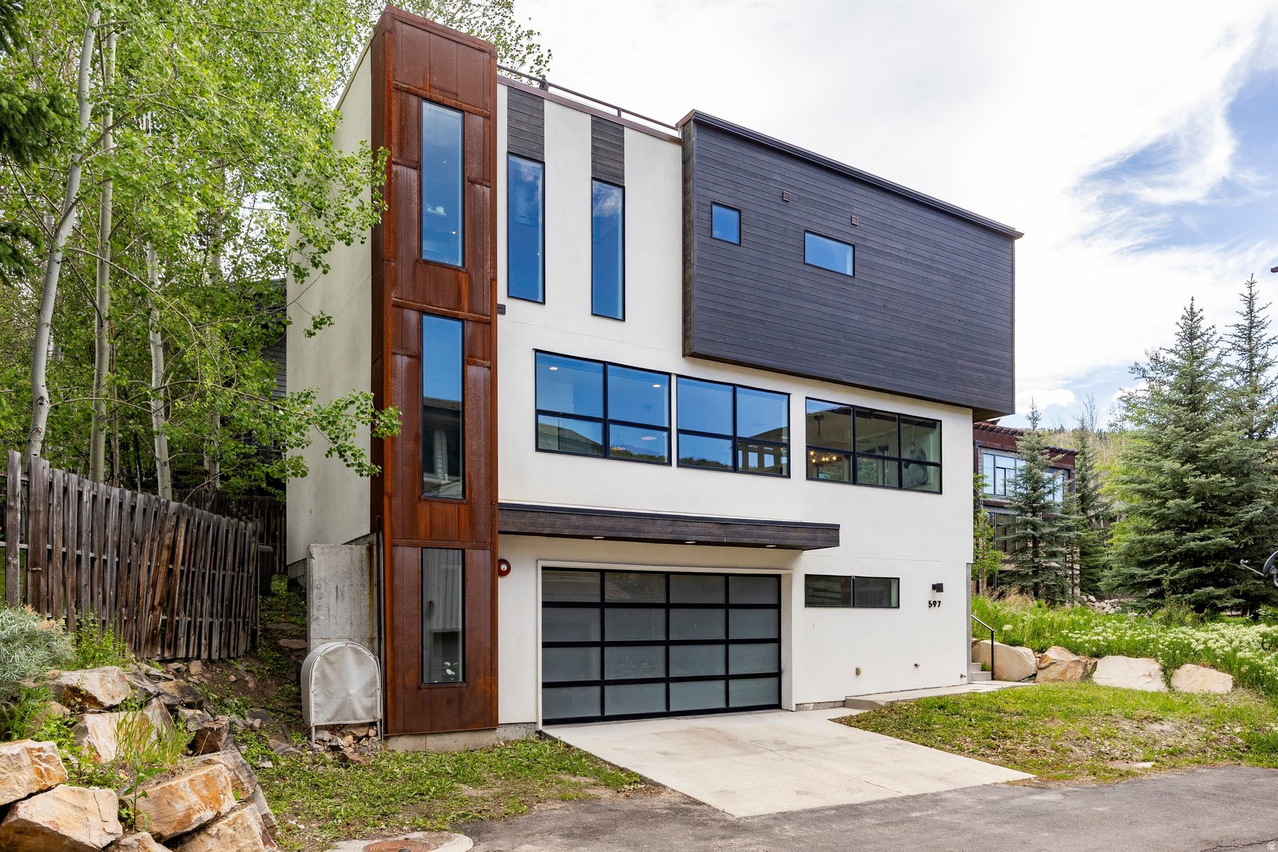 Perfectly positioned between Old Town and Lower Deer Valley, this modern single-family home offers the ideal combination of privacy, convenience, and nightly rental flexibility. Just a quick walk to the bus route, dining, shopping, Main Street, and Deer Valley's summer concerts, the location works beautifully as a primary residence, vacation home, or investment property. The home is light, bright, and contemporary, with clean lines, wide-plank white oak floors, quartz countertops, stainless appliances, and an open main-level layout designed for easy gathering. The living room has been enhanced with a gas fireplace and stone surround, adding warmth and texture to the space and creating an inviting place to relax after a day on the mountain. The rooftop patio is the true showstopper, now finished with a full metal railing and framed by beautiful ski run and mountain views. It is the perfect place to enjoy sunny afternoons, summer evenings, and Park City's spring, summer, and fall seasons. Additional outdoor living includes a lower patio with a Bullfrog spa, matching railing, BBQ grill, and patio furnishings. Since purchasing the home, the sellers have thoughtfully updated and furnished the property with help from Jenn Mangum in Midway. Improvements include new furnishings, artwork, four flat-screen TVs, stocked kitchenware, patio furniture, a remodeled bunk room with two sets of bunk beds, a barn door added to the primary suite, a stacked washer and dryer on the main level, and a second washer and dryer in the garage owner's closet for cleaner use between guests. Offered fully furnished and truly turnkey, this home is ready for immediate enjoyment, rental use, or a seamless Park City lifestyle in one of the most convenient locations in town.