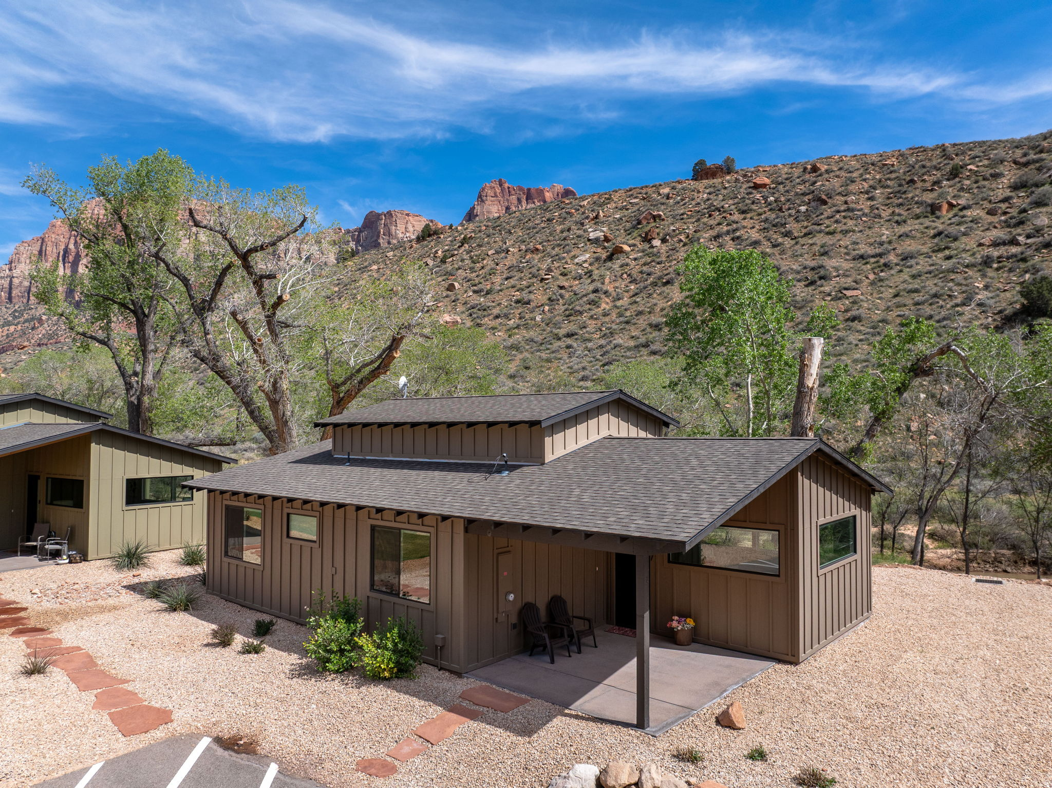"RARE RIVERFRONT" opportunity in the heart of Springdale, just minutes from Zion National Park!  Tucked along the scenic Virgin River & surrounded by towering red rock cliffs, this beautifully designed home is located within the intimate Canyon Cottonwood Cottages community-comprised of only 9 residences, with just 3 offering coveted riverfront positioning... and this is one of them! Thoughtfully designed with clean, modern finishes, this 2-bedroom, 2-bath home offers approximately 1,400 sq ft of total living space, including a versatile loft-ideal for additional sleeping space, a home office, or a cozy retreat. Expansive windows frame breathtaking views of Zion's iconic landscape, bringing the outdoors in and creating a light, airy feel throughout. The open-concept living area flows seamlessly into a well-appointed kitchen featuring sleek cabinetry, quartz countertops, & stainless appliances. Step outside & enjoy direct access to the Virgin River, w/peaceful surroundings perfect for unwinding after a day of hiking or biking. Ideally located on the south end of Springdale, you're just moments from Zion National Park, world-class hiking & biking trails, boutique shops, art galleries, and some of the area's most sought-after dining. Whether you're searching for a private getaway, investment opportunity, or full-time residence, this is a truly exceptional opportunity in one of Southern Utah's most iconic settings. County records may not reflect the additional approximately 300 sq ft loft space. Buyer to verify all information, including square footage.