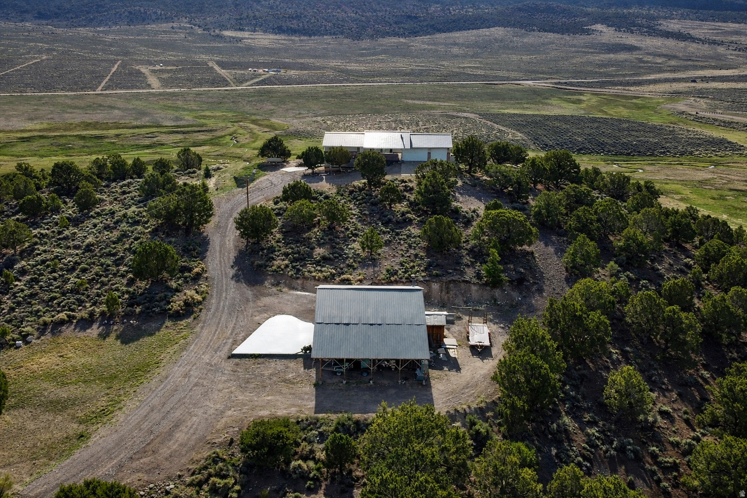 If you want views that truly stop you in your tracks, this is the place.  Set on the east side of Burrville Hill overlooking Koosharem Reservoir, this 4-bedroom, 3-bath home rests on 20.00 acres of open ground and big Utah sky. The setting alone is hard to beat - quiet, private, and perfectly positioned to capture those unforgettable east-facing sunrises rising over the water.  Inside, you'll find a well-appointed kitchen, warm and inviting living spaces, and a wood-burning fireplace that makes winter evenings feel exactly the way they should. Propane heat keeps the home comfortable year-round.  Step onto the east-facing deck and you'll immediately understand what makes this property special - wide open views, fresh air, and room to breathe.  The home offers a 2-car attached garage plus a large detached garage, providing ample space for vehicles, recreational toys, storage, or a workshop. A dedicated game room adds flexibility and includes a Murphy bed, making it ideal for additional guests or multi-purpose use.  Whether you're looking for a full-time residence, a secondary home, or a private retreat, this property offers the rare combination of acreage, privacy, functionality, and truly unforgettable views - all in one remarkable location.