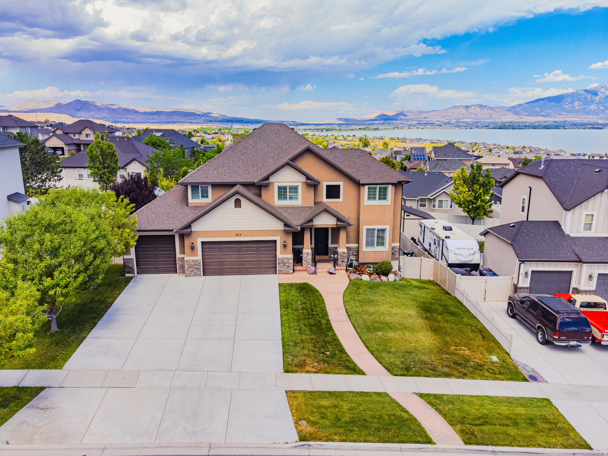 Experience elevated living in this beautifully updated Saratoga Springs home, perfectly situated across from Stillwater Park with breathtaking views of Utah Lake and the Wasatch Mountains. Offering over 5 bedrooms, 3.5 bathrooms, and thoughtfully designed living spaces, this home blends luxury finishes with everyday comfort. The open-concept main level features rich flooring, custom accent walls, plantation shutters throughout, a striking floor-to-ceiling fireplace, and a gourmet kitchen complete with quartz countertops, an oversized island, gas range, and abundant cabinetry. Retreat to the spacious primary suite featuring a beautifully remodeled spa-inspired bathroom with a corner jetted tub, oversized walk-in shower, and designer finishes. Step outside to the covered Trex deck and enjoy panoramic lake and mountain views, or relax beneath the backyard pavilion while taking advantage of the fully fenced yard. The finished walk-out basement is an entertainer's dream, complete with a sleek kitchenette, spacious family room, dedicated home gym, and private sauna, offering incredible flexibility for guests, recreation, or multigenerational living. A 3-car garage, RV parking, and generous storage complete the package. Located just 3 minutes from TalonsCove Golf Club and Utah Lake, less than 10 minutes from Pioneer Crossing, Costco, FatCats, shopping, dining, and entertainment, with access to outstanding community amenities including a pool, fitness center, clubhouse, and parks. This is a rare opportunity to own a home that combines luxury finishes, unforgettable views, and an exceptional Saratoga Springs lifestyle. Buyer is advised to independently verify all measurements and property information to their satisfaction.