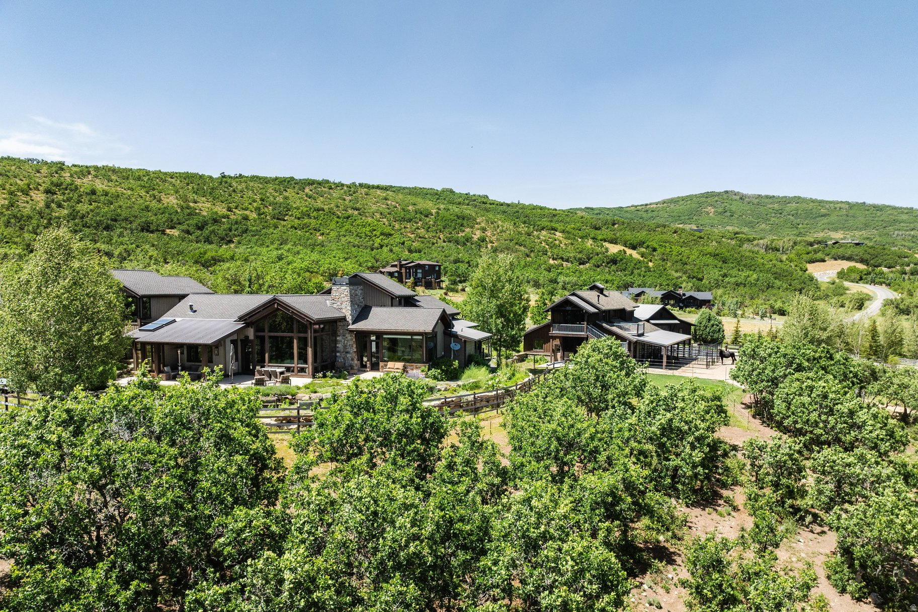 Wake up each morning to the peaceful serenity of mountain living, where panoramic ski resort and Wasatch Mountain views make every day feel like a private retreat. This extraordinary Park City equestrian estate blends refined luxury, unmatched privacy, and an authentic horse-property lifestyle just minutes from world-class skiing, golf, dining, and Historic Main Street. Designed for discerning equestrians and outdoor enthusiasts alike, the property features a custom 4-stall barn with a beautifully finished apartment above - perfect for guests, staff quarters, or a private office retreat. The equestrian amenities continue with 6 acres of fenced pasture, a round pen, outdoor riding arena, and direct access to miles of scenic trails, allowing you to ride straight from the property with no trailer required. Inside, the residence is filled with natural light and framed by breathtaking mountain vistas from nearly every room. Vaulted ceilings, expansive picture windows, inviting gathering spaces, and seamless indoor-outdoor living create a sophisticated yet relaxed mountain ambiance. Multiple terraces and outdoor entertaining areas set the stage for sunset dinners, quiet mornings overlooking the pasture, and unforgettable evenings under the stars. Offering direct access to Park City's year-round lifestyle - including horseback riding, hiking, biking, skiing, and snowshoeing - this is a rare legacy property for those seeking luxury mountain living with space for horses, recreation, and unforgettable views.
