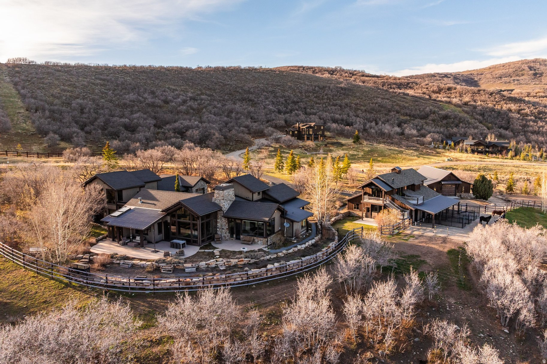 Wake up each morning to the peaceful serenity of mountain living, where panoramic ski resort and Wasatch Mountain views make every day feel like a private retreat. This extraordinary Park City equestrian estate blends refined luxury, unmatched privacy, and an authentic horse-property lifestyle just minutes from world-class skiing, golf, dining, and Historic Main Street. Designed for discerning equestrians and outdoor enthusiasts alike, the property features a custom 4-stall barn with a beautifully finished apartment above - perfect for guests, staff quarters, or a private office retreat. The equestrian amenities continue with 6 acres of fenced pasture, a round pen, outdoor riding arena, and direct access to miles of scenic trails, allowing you to ride straight from the property with no trailer required. Inside, the residence is filled with natural light and framed by breathtaking mountain vistas from nearly every room. Vaulted ceilings, expansive picture windows, inviting gathering spaces, and seamless indoor-outdoor living create a sophisticated yet relaxed mountain ambiance. Multiple terraces and outdoor entertaining areas set the stage for sunset dinners, quiet mornings overlooking the pasture, and unforgettable evenings under the stars. Offering direct access to Park City's year-round lifestyle - including horseback riding, hiking, biking, skiing, and snowshoeing - this is a rare legacy property for those seeking luxury mountain living with space for horses, recreation, and unforgettable views.
