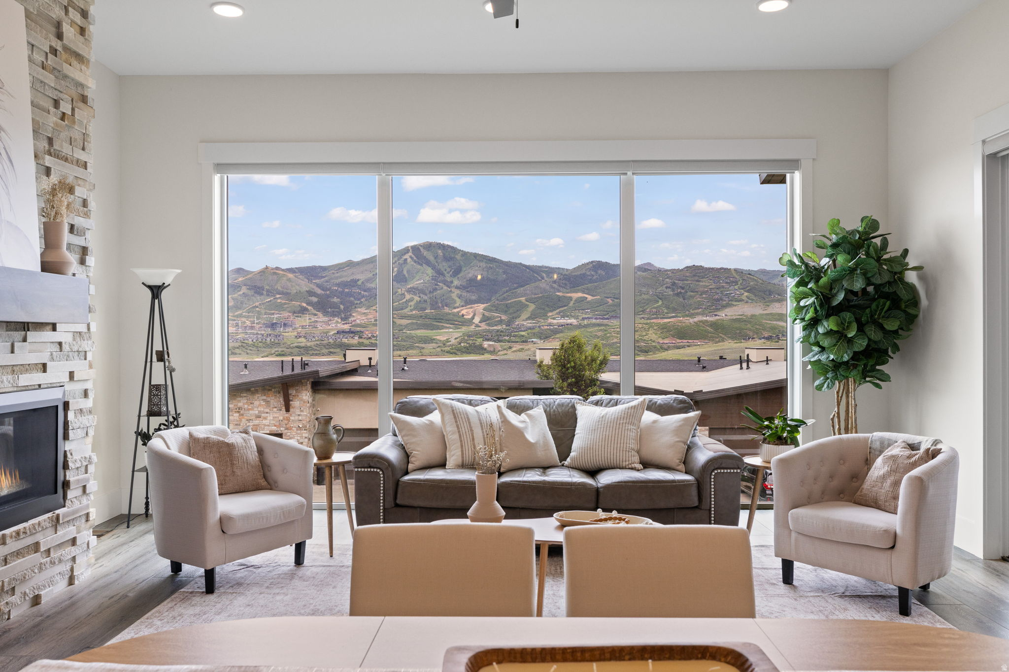 Experience the best of mountain living in this turnkey townhome with sweeping views of Jordanelle Reservoir and Deer Valley East Village. Filled with natural light and thoughtfully designed for main-level living, this home offers an open-concept floor plan, soaring ceilings, and large windows that showcase the surrounding landscape.  The kitchen features quartz countertops, JennAir appliances, a coffee bar, and walk-in pantry, flowing seamlessly into the great room with a gas fireplace and upgraded stone surround. Step onto the covered deck to enjoy spectacular sunsets and views. The front porch offers the perfect morning coffee spot to start your day.  The spacious primary suite offers a soaking tub, separate shower, dual vanities, and a walk-in closet. Downstairs, the walkout lower level provides space for family and guests with a second living room, electric fireplace, media room with a 90-inch screen and surround sound, two additional bedrooms, a shared bath, and a dry bar with wine refrigerator.  Additional highlights include a Tesla charger, fiber internet, dual-zone climate control, solid wood doors, upgraded steel railings, abundant storage, and dedicated ski and bike storage in the garage.  Ideally located just minutes from Deer Valley East Village, Park City, Heber City, Jordanelle State Park, and the Uinta Mountains, this home offers easy access to skiing, boating, hiking, biking, and countless outdoor adventures while providing the peace and tranquility of a quiet mountain retreat.