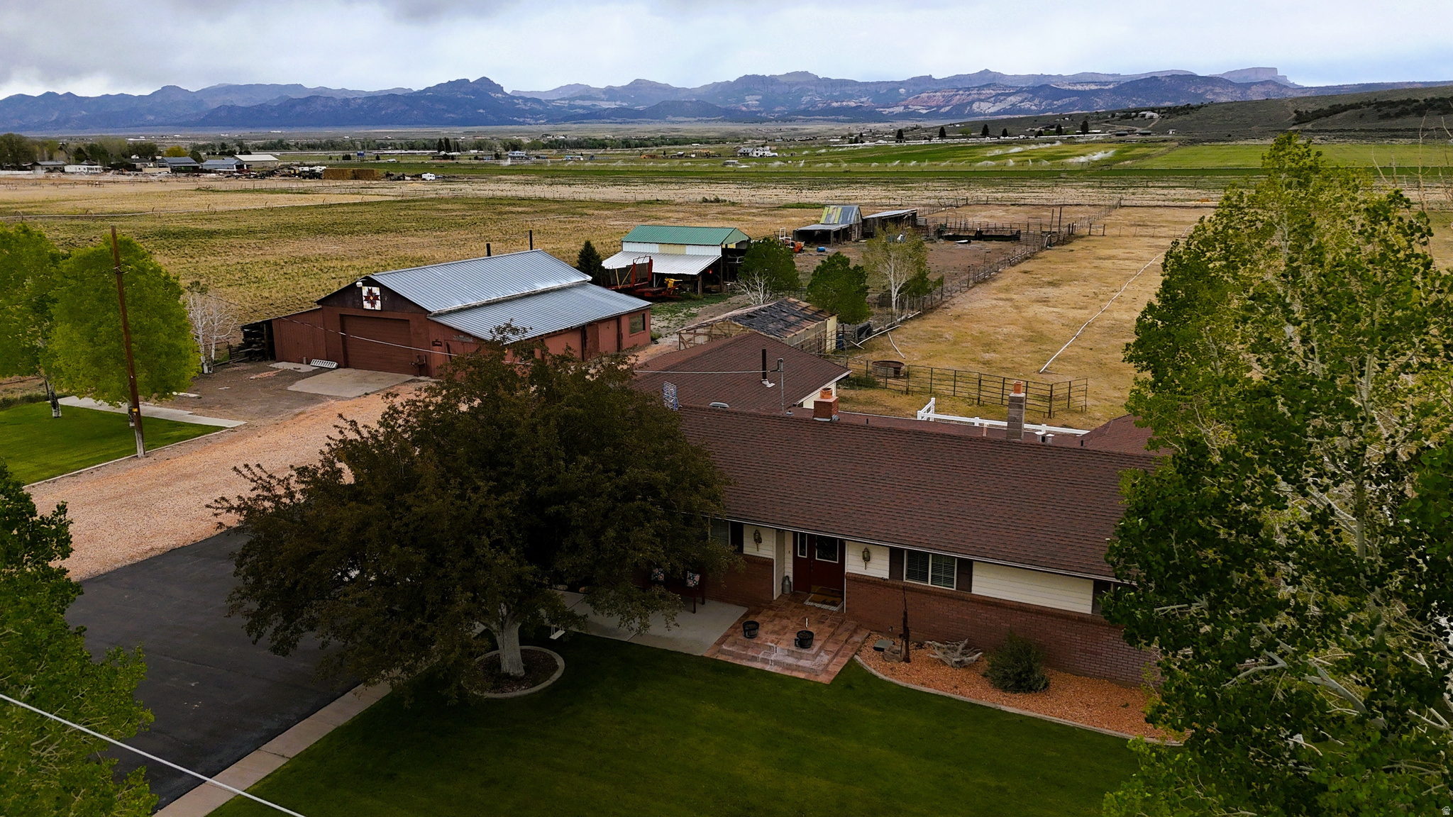 Located on the edge of town in the scenic valley town of Panguitch, this 10.34-acre property offers a combination of residential living, irrigated acreage, agricultural infrastructure, and mountain views. The property provides convenient access to local schools, shopping, dining, and community services while maintaining a quieter rural setting with open space and views across the farms in the valley and the surrounding mountains.  The ranch-style rambler home includes approximately 2,158 square feet of finished living space along with an unfinished basement of approximately 730 square feet. The basement offers additional storage. The home sits within a well-established agricultural setup that supports livestock, hay production, and equipment storage. This property would be well-suited for those with animals or families looking to operate a hobby farm.   Approximately 7 acres are currently planted in alfalfa and irrigated with wheel lines. An additional 1.5-acre horse pasture is irrigated with hand lines and is set up for equestrian or livestock use. The property includes 15 shares of irrigation water through West Panguitch Irrigation Company, supporting the agricultural use of the land.  The improvements on the property provide functional utility for agricultural operations, equipment storage, hobbies, or workshop use. A 2,100 square foot shop includes side storage space and offers room for tools, machinery, recreational equipment, or project work. Additional improvements include a 47x33 hay barn, horse stalls and sheds, several smaller outbuildings, and a Conex storage container.  The acreage is relatively level and usable, making it suitable for a variety of rural lifestyle and agricultural applications. The combination of irrigated ground, pasture, storage facilities, and residential improvements creates flexibility for buyers seeking space for animals, farming activities, equipment storage, or country living near town amenities.  The property is located within minutes of downtown Panguitch and provides access to outdoor recreation opportunities throughout Southern Utah. Nearby public lands, reservoirs, and mountain ranges support fishing, hiking, horseback riding, ATV use, and seasonal recreation. The area also serves as a gateway to destinations such as Bryce Canyon National Park and Dixie National Forest.  The home price has been set according to a recent appraisal, which the seller is willing to share with qualified buyers. Whether used as a primary residence, hobby farm, horse property, or agricultural investment, this property presents a combination of acreage, water rights, improvements, and accessibility in Southern Utah.