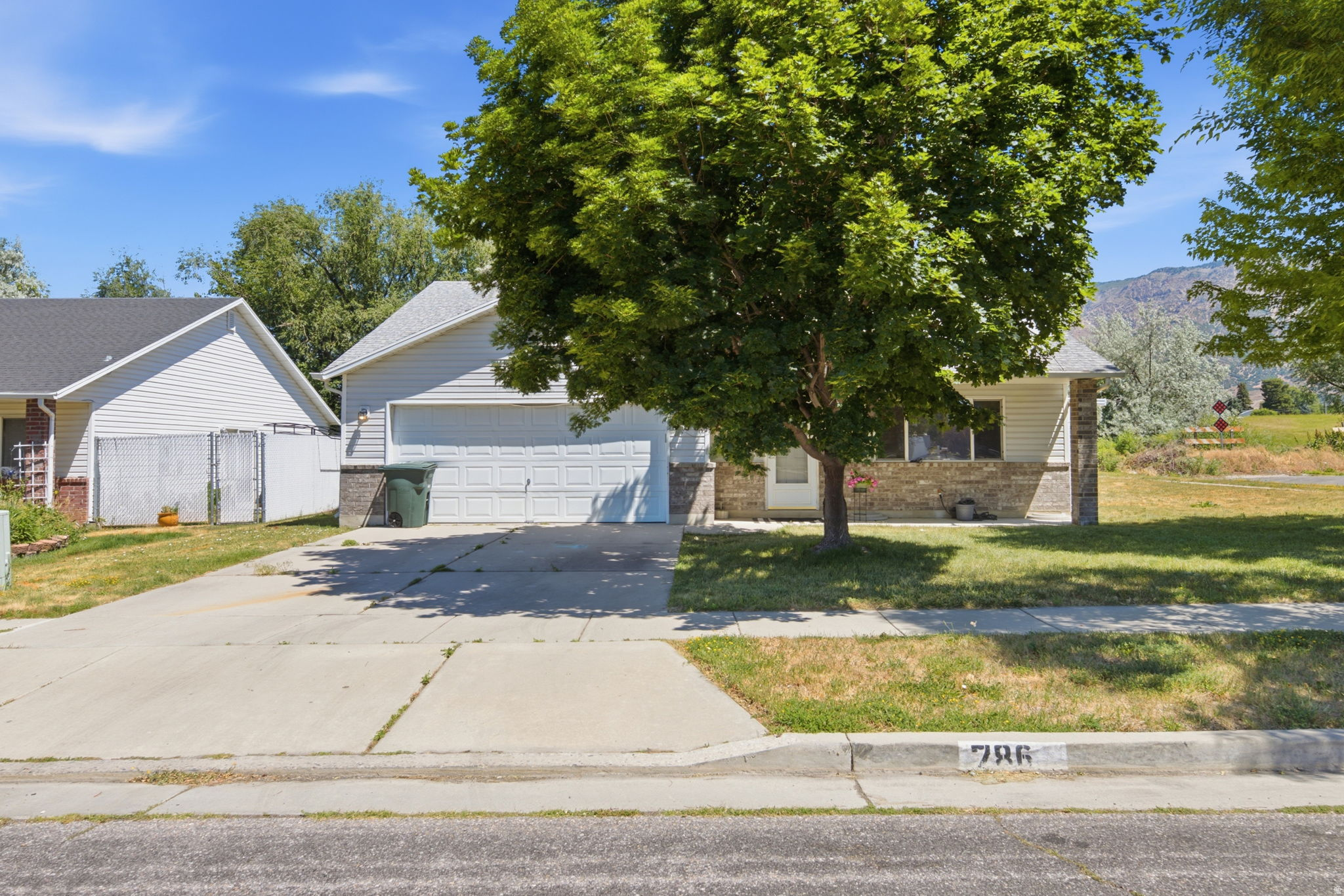 GRAND OPENING | OPEN HOUSE | JUNE 20 | 12PM-2PM | Welcome home to this beautifully maintained single-level home nestled on a spacious corner lot beneath the stunning backdrop of Ben Lomond Peak. Offering 3 bedrooms and 2 bathrooms, this home combines low-maintenance living with comfort and style.  Step inside to find new laminate wood flooring throughout the main living areas, creating a warm and inviting space that's perfect for everyday living and entertaining. The thoughtfully designed floor plan provides easy, single-level accessibility with generous natural light throughout.  Enjoy added privacy with no backyard neighbors, allowing you to relax and take in the peaceful mountain surroundings. A newer A/C unit (less than 3 years old) provides added comfort and peace of mind during Utah's warmer months