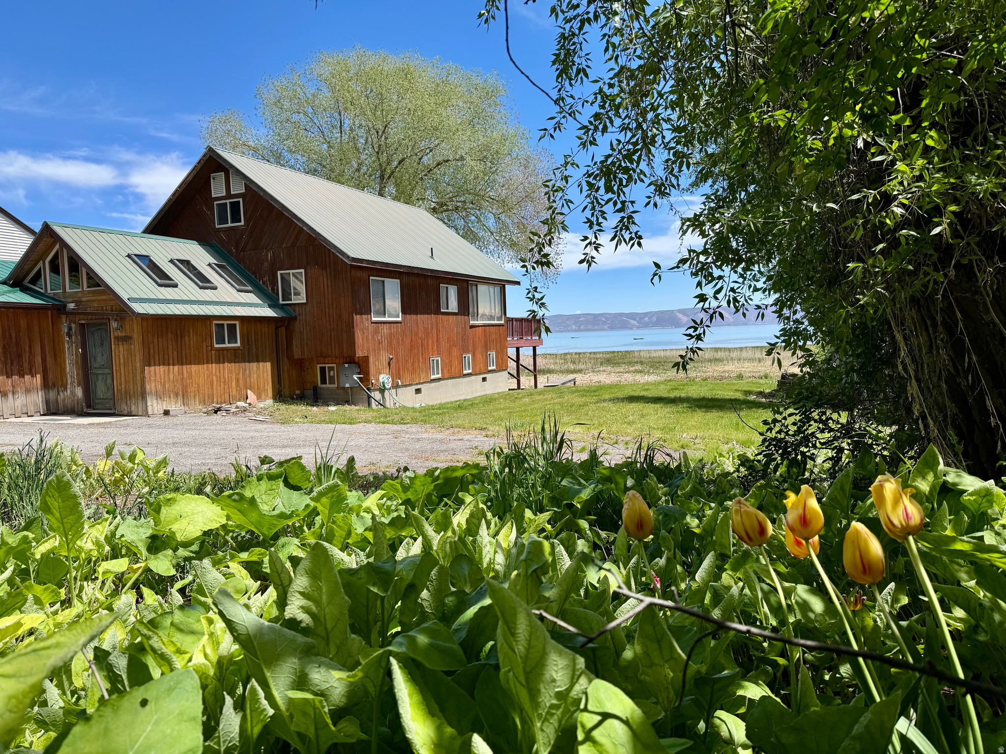 Own WATERFRONT on beautiful Bear Lake with expansive VIEWS and mature TREES!  This property offers flexibility for building, expansion, or redevelopment. The home, reminiscent of mid-century modern cabin,  is enjoyed, and has been for years; however, the primary value lies in the land and location.  For those who want to create something truly their own, this is a unique opportunity to design and build in one of Bear Lake's most desirable settings and bring a personalized vision to life.  Utilities are in place, along with recently completed drainage improvements designed to manage seasonal water runoff. Opportunities are limited along Bear Lake's shore. Enjoy optimal year-round recreation close to Bear Lake West GOLF COURSE, Cooper's RESTAURANT, Bear Lake MARINA in Garden City, North BEACH/Boat Launch and Minnetonka Cave in St. Charles. Snowmobile/ATV TRAILS only minutes to Fish Haven Canyon, and 30 minutes to Beaver MOUNTAIN SKI Resort. Property is being sold as-is buyer to verify all information.  Square footage figures are provided as a courtesy estimate only.  Buyer is advised to obtain an independent measurement.