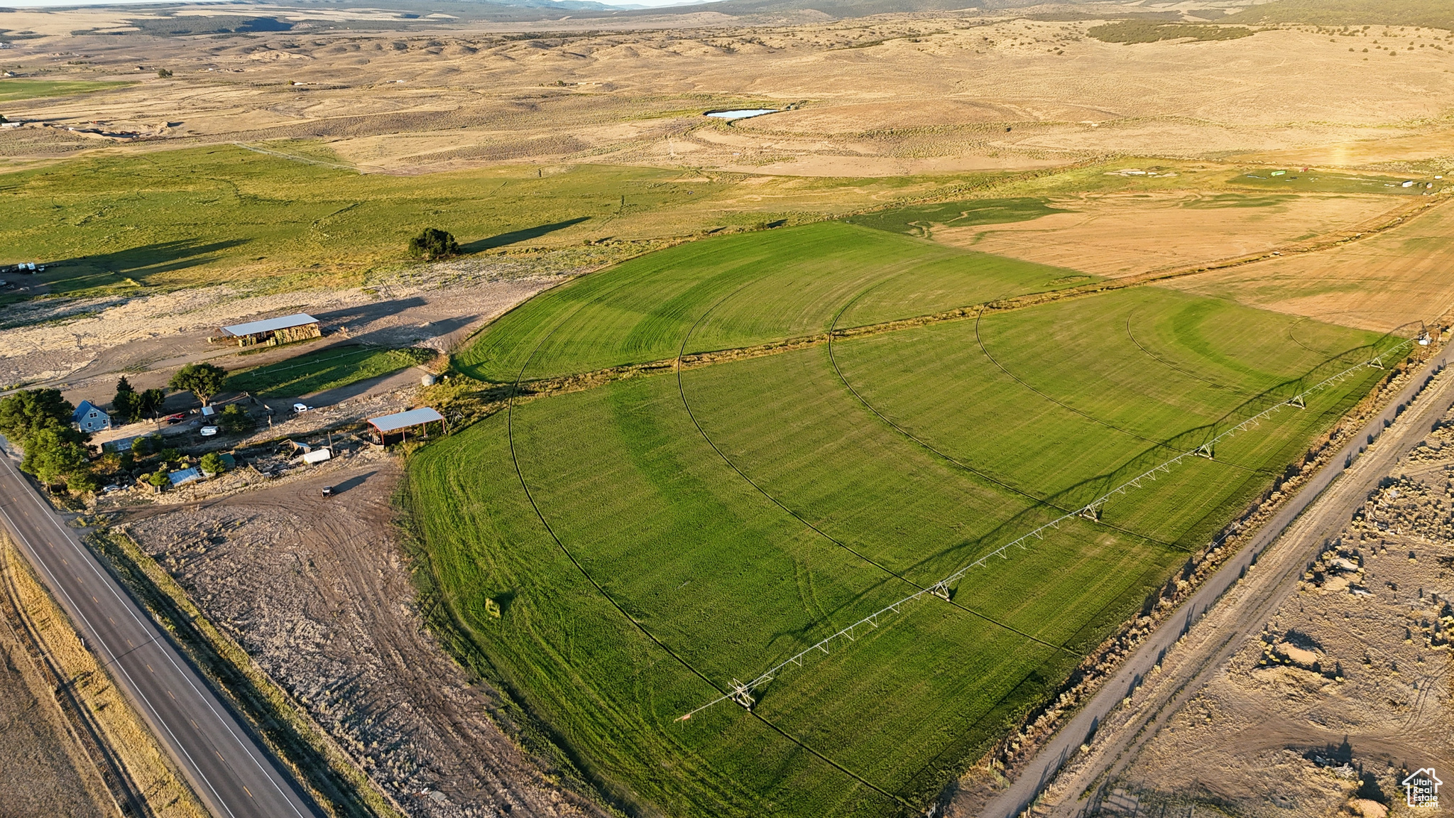 This 50-acre property in Garfield County, Utah, offers a rare combination of accessibility, infrastructure, and development potential. Located just 4 miles from the town of Panguitch, the land features direct Highway 89 frontage, making it suitable for residential, commercial, or agricultural use. The terrain is mostly flat with a gentle slope to the east, providing panoramic mountain views and sightlines toward the river bottom valley. Utilities and water are already in place, lowering the cost and complexity of development. Included with the property are underground water rights (Water Right 61-391) totaling 10.86 acre-feet, or 130 equivalent livestock units, along with shares in the West Panguitch Irrigation and Reservoir Company. A pivot irrigation system waters much of the property, and soils in the region have supported productive crops and hay for many years. On-site improvements include two hay barns totaling 10,000 square feet of covered storage, perimeter fencing, stock corrals near the highway, and agricultural infrastructure already in place. Well depths in the area range from 80 to 150 feet, offering reliable water access. With only 5% of Garfield County privately owned, buildable parcels with utilities and water rights are increasingly scarce. This property's features make it adaptable to a wide variety of uses, from a single-family home site or subdivision to agricultural expansion or a commercial base of operations. The property's location offers quick access to essential services and a range of recreational destinations. Panguitch provides dining, fuel, shopping, and an airport only minutes away. Nearby attractions include Bryce Canyon National Park, Zion National Park, Dixie National Forest, and two ski resorts-Brian Head and Eagle Point-as well as numerous lakes, trails, and public lands