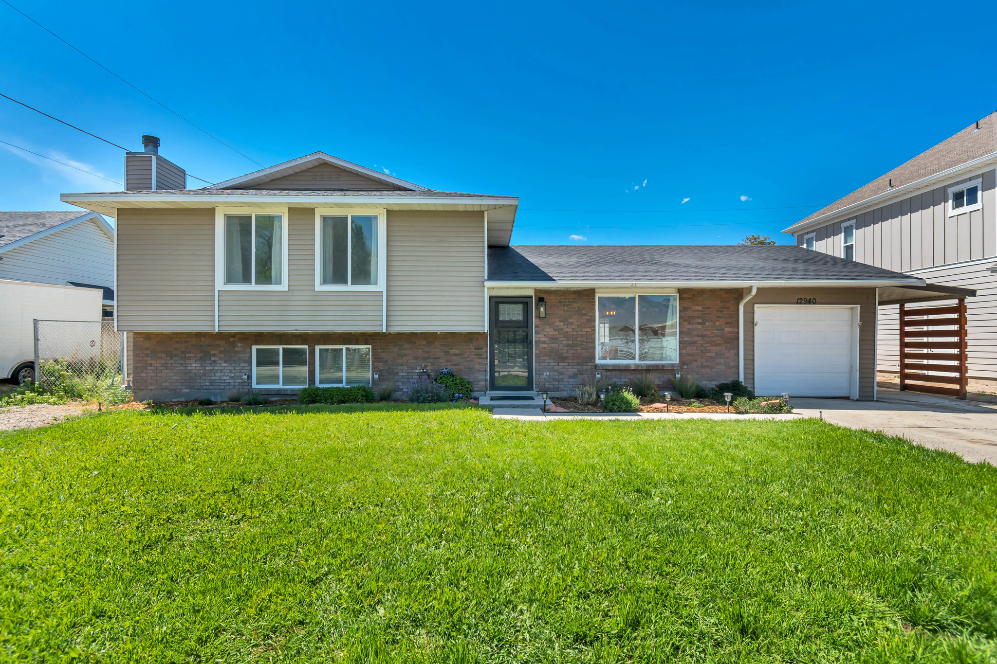Updated Riverton home with standout indoor and outdoor living space. The fully fenced yard features a fire pit and a huge covered patio with a hot tub that's perfect for entertaining, BBQs, or relaxing at home. You'll also love the extra parking options with a one-car garage, covered carport, and RV parking. Inside, the home gets great natural light and features hardwood flooring, updated knotty alder cabinets, granite countertops, stainless steel appliances, updated light fixtures and faucets, and both formal and casual living areas. The primary suite includes double closets and a private bathroom, while the daylight basement offers a large second suite with its own ensuite bath that creates a great setup for guests or multigenerational living. Recent updates include HVAC replaced 2 years ago and a newer dishwasher. Additional benefit of secondary irrigation water at only $21/month. Tankless water heater installed. Possible opportunity for qualified buyers to assume the seller's existing 2.5% FHA loan. Contact agent for details and lender qualification requirements.