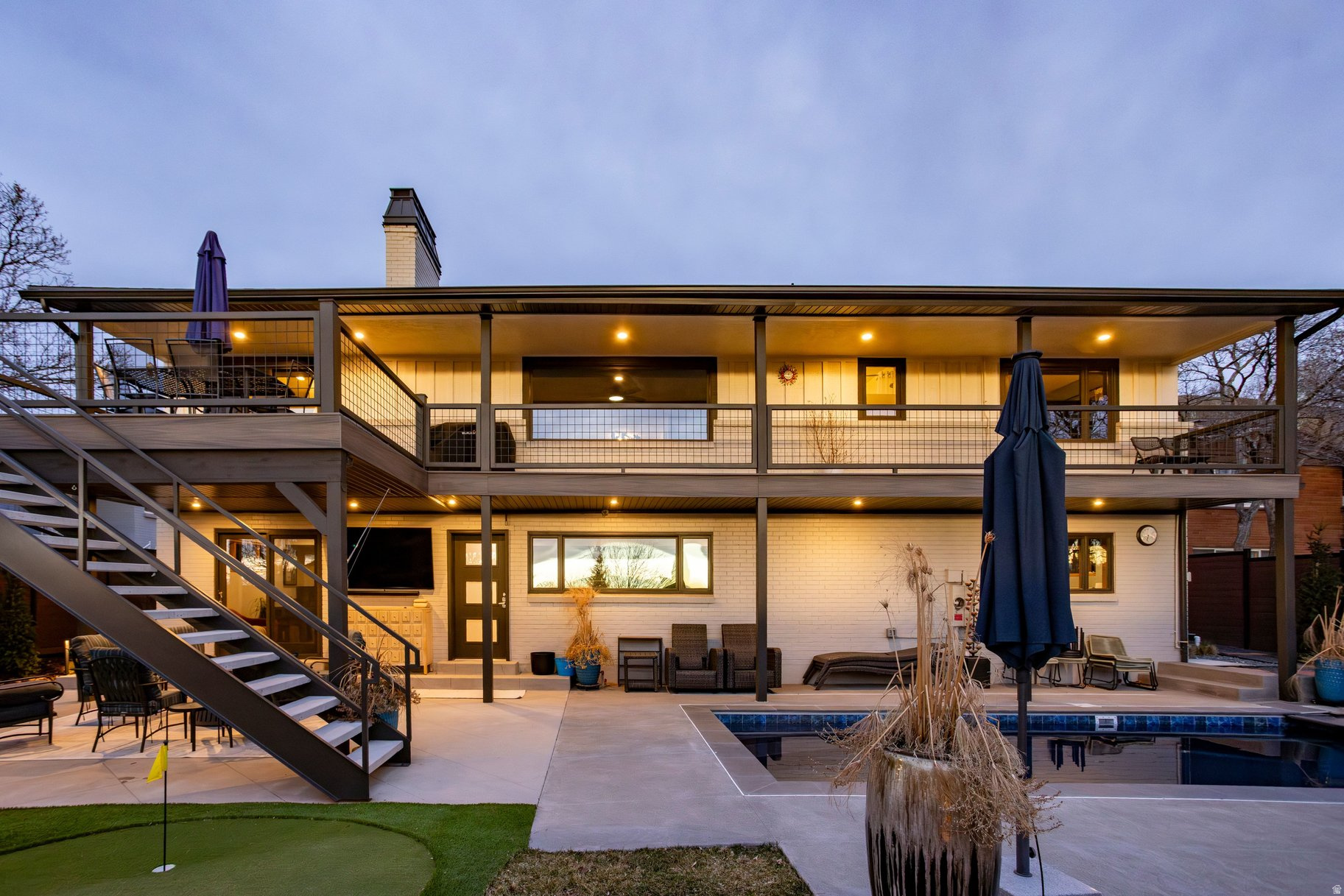 Perched above the city in a coveted hillside setting, this stunning residence has been completely remodeled inside and out, offering refined luxury, modern design, and breathtaking city views. Thoughtfully curated finishes and impeccable craftsmanship define every space, creating a turnkey home for sophisticated living and entertaining. The gourmet kitchen is the heart of the home, featuring premium appliances, custom cabinetry, and elegant surfaces-perfect for both everyday living and elevated gatherings. The main-level primary suite provides a private retreat with a beautifully appointed spa-like bathroom and a generous walk-in closet. The lower level is designed for effortless entertaining, featuring a stylish bar and entertainment area, along with an additional guest suite with its own ensuite bathroom-ideal for visitors or multi-generational living. Outdoor living is equally exceptional, with a resort-style pool, hot tub, and fire pit creating an inviting backdrop for year-round enjoyment. Expansive terraces and outdoor spaces capture sweeping city lights and skyline views, making this property a true entertainer's dream. A spacious three-car garage completes this remarkable offering, providing ample storage and convenience in one of Salt Lake City's most desirable neighborhoods.