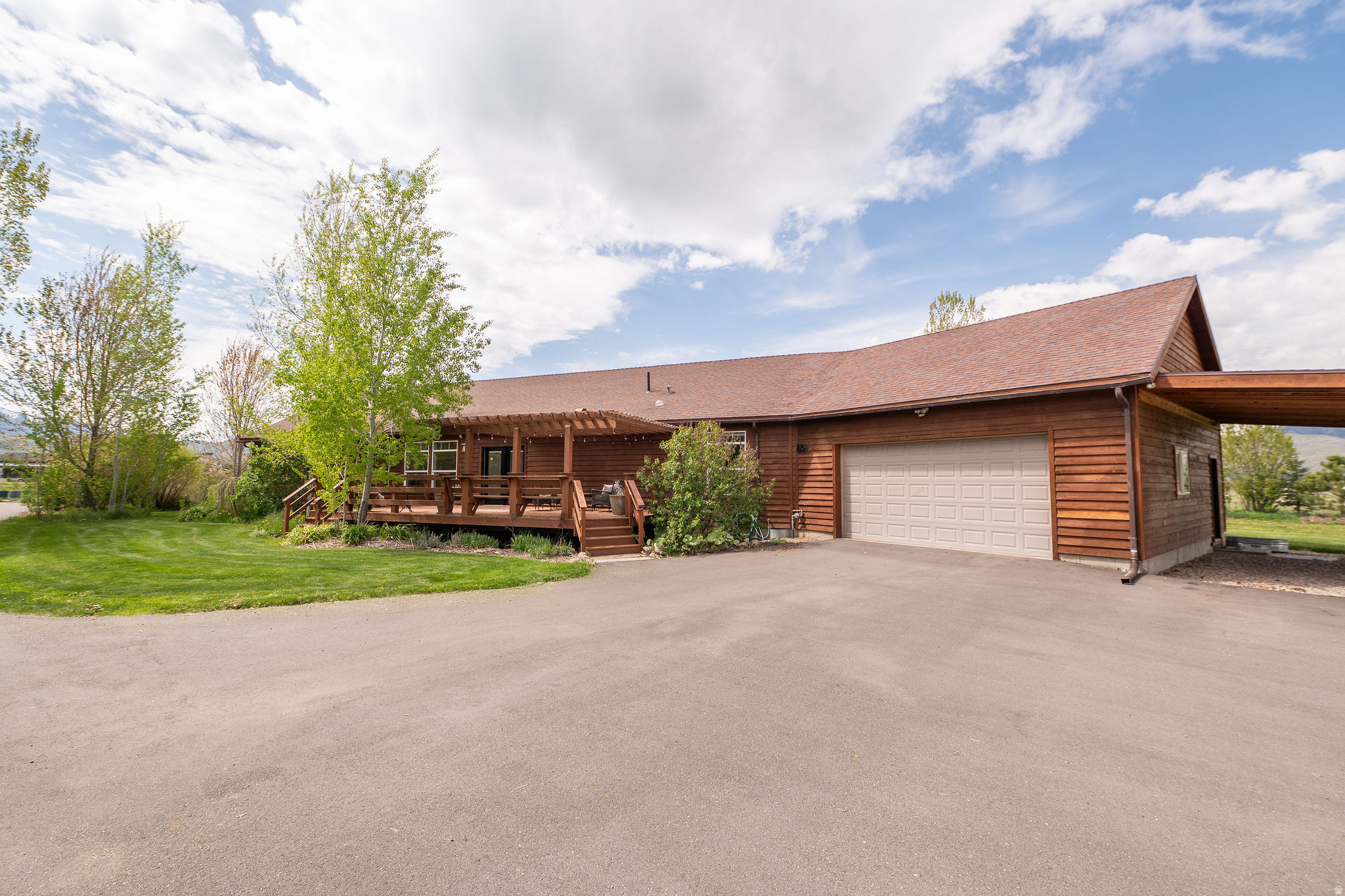 Wake up to peaceful country living on 5.05 acres in this 3-bed, 2-bath, 2,114 sq ft home. Start your morning gathering fresh eggs, tending the garden, or walking through your permaculture orchard and hay field. Enjoy an open layout with a living room filled with natural light and views of the Wasatch Mountains and Snowbasin Ski Resort. Make memories cooking in a spacious kitchen featuring a butcher block island, breakfast bar & pantry. Unload groceries with ease through the mudroom off the attached 2-car garage. Spend your afternoons in the heated shop with a loft + bonus room, perfect for hobbies, a workshop, or she-shed. Entertain on one of three sunny decks. Park your RV under covered carports, then wind down in the evening in your private primary suite with ensuite bath, jetted tub, separate shower & walk-in closet...or end the day unwinding in your cedar sauna. It's not too good to be true, see it for yourself! Square footage figures are provided as a courtesy estimate only and were obtained from county records.  Buyer is advised to obtain an independent measurement.