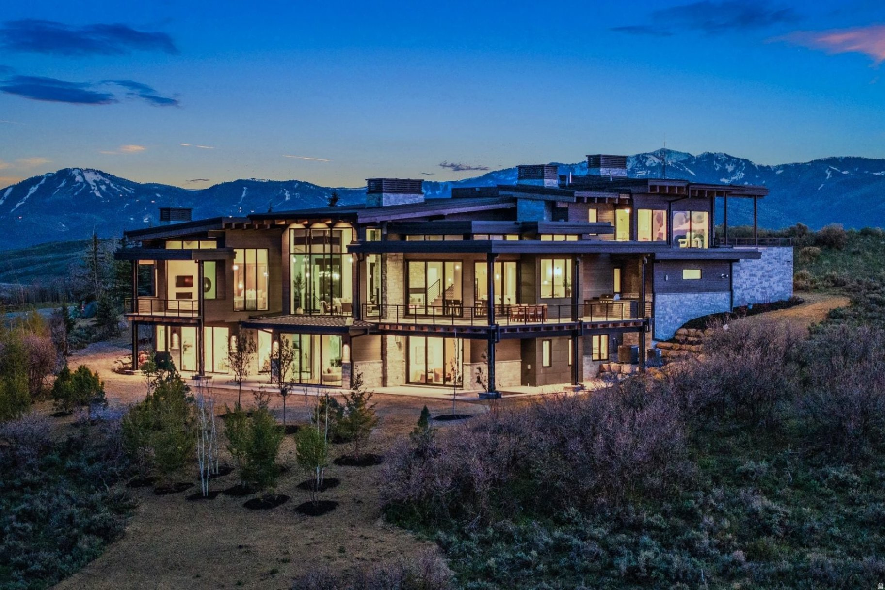 Framed by expansive mountain views and set along a high ridge in Promontory, this residence captures sweeping vistas of Park City Mountain Resort, Deer Valley, and the Wasatch Range. Crafted by Aecum Development taking full advantage of both the surroundings and privacy, the home offers a composed and elevated sense of arrival, perfectly positioned by golf and mountain landscape. Thoughtfully designed for everyday living and entertaining, the residence features beautifully appointed en-suite bedrooms, including two primary suites with spa-inspired baths with generous closet space. Expansive decks and patios extend the living experience outdoors, while refined gathering spaces and comfortable guest accommodations create a timeless mountain retreat. The kitchen is both functional and refined, anchored by Wolf and Sub-Zero appliances, while complemented by a fully equipped butler's pantry with multiple prep areas and abundant storage -allowing for seamless flow when entertaining. Additional features include radiant heating, a heated driveway, a four-car garage, and a custom mudroom with built-in storage for coats, boots, and gear. A private gym and sauna complete the home, offering a quiet place to unwind after a day outdoors. With world-class golf, skiing, and year-round recreation just moments away, the residence offers a lifestyle that is both elevated and effortlessly connected to its surroundings.