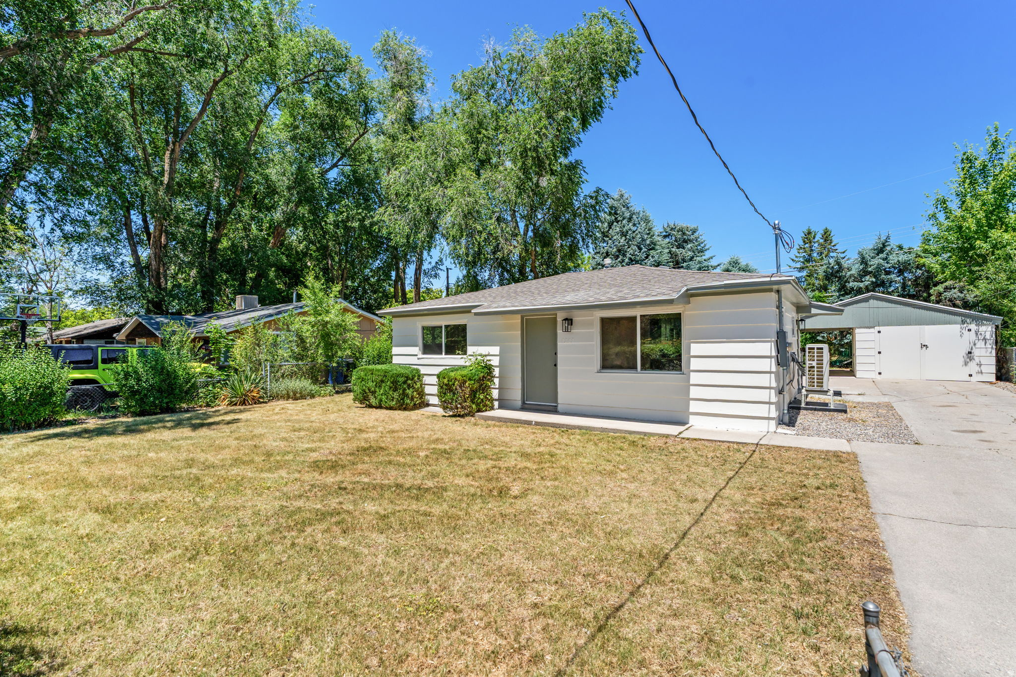 Looking for a yard, RV parking, and outdoor space? Discover this quaint single-family home in the beautiful Millcreek area! This charming residence has been thoughtfully updated to offer modern comfort while maintaining its cozy character. The entire home has been rewired with a new electrical box, ensuring safety and efficiency. Enjoy updated lighting and plumbing throughout the space. The kitchen features stunning sage green cabinets, new appliances, new plumbing, and a functional layout perfect for cooking and entertaining. The bathroom has been redesigned for optimal space usage. The stack-able washer and dryer is conveniently tucked away in a closet. The exterior has been freshly painted in a creamy white with green accents, providing a modern yet refreshing look. Enjoy a fully fenced yard with lush greenery and shady trees, perfect for relaxation and outdoor activities. Enjoy the separate garage with updated electrical and has been re-roofed for added usability, plus a carport patio that can serve as additional storage or an outdoor dining area. Take in the breathtaking views of the surrounding mountains. Benefit from the prime location, close to local shopping, dining,  and recreational opportunities. Schedule your showing today and make this charming home your own! Buyer and Buyer's agent to verify all information. Home Warranty included $750 value! Owner/Agent