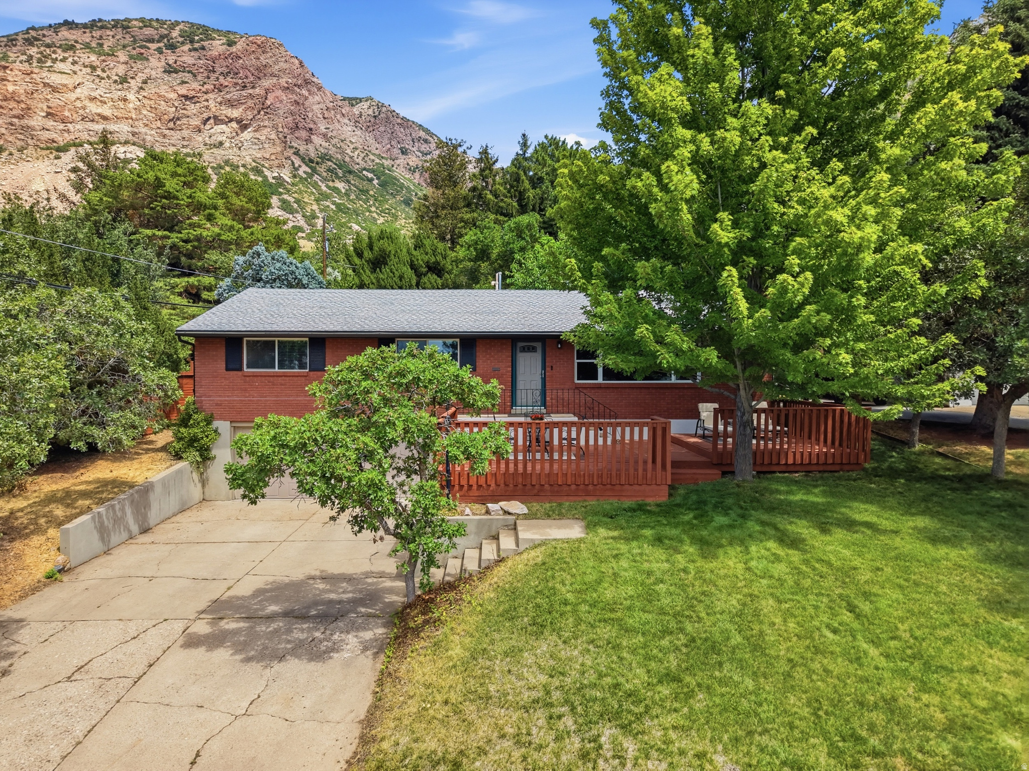 For those patiently waiting for a listing on Ogden's East Bench with three bedrooms on the main level, attached two car garage, and a dedicated dining space, congratulations! Your wait is over. Located on Ogden's renowned Buchanan Avenue, just one block from both the 27th Street and 29th Street trailheads, this all-brick rambler has the perfect mix of mid-century charm and functional modern living. Situated on a spacious lot, the property features two idyllic spots from which to relax: the patio located in the serene, fully fenced backyard and the recently refinished wood deck in the front offering sublime views of the Salt Lake Basin. Inside, the upstairs has a special layout with three bedrooms on the main level and a dedicated dining space with a sliding glass door that flows seamlessly into the backyard. The semi-open, spacious updated kitchen is a host's dream. Aesthetically, the interior beautifully preserves its mid-century heritage with authentic wood paneling, charming built-ins, and original tilework in the bathroom, while tastefully blending modern updates like granite countertops and a gas fireplace insert. However, the attached oversized two-car garage truly makes this property stand apart from its peers. In fact, no other property has sold this year at this price point on Ogden's East Bench (between 20th and 35th St) that had 3 bedrooms + on the main level, a dedicated dining space, and an attached two car garage -- let alone this close to the mountain! Statistically speaking, as well as aesthetically, this home is a true outlier; a veritable East Bench Gem. The first weekend is reserved for private showings only. Open house next Saturday August 1st.