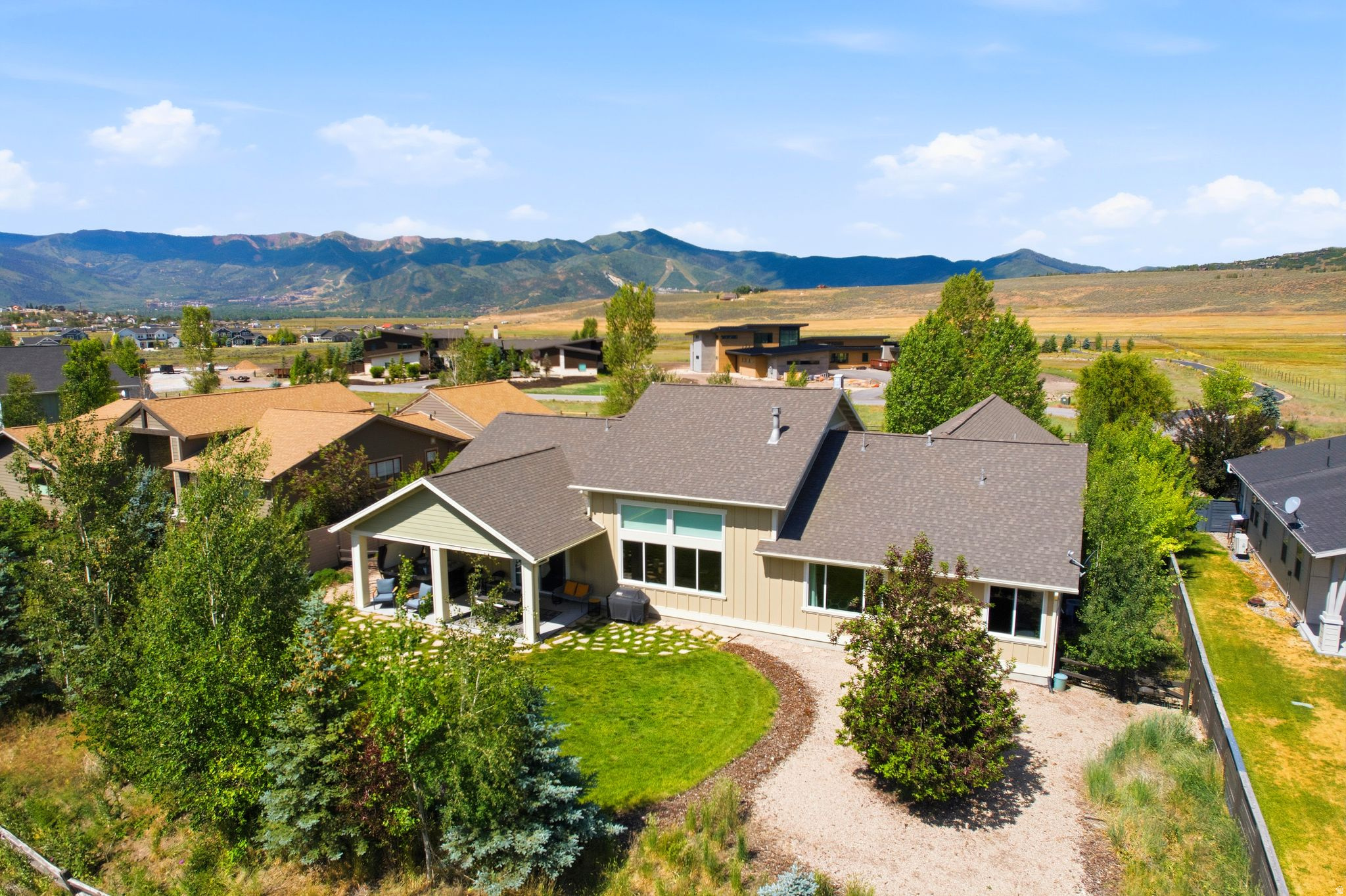 Enjoy the ease of single-level living in this beautifully maintained and move-in-ready home, thoughtfully designed for comfortable everyday living and effortless entertaining. Situated on a quiet street in one of Park City's most convenient residential neighborhoods, 7060 Greenfield Drive offers a spacious, flexible floor plan with quality finishes, abundant natural light, and inviting indoor and outdoor living spaces.  The expansive kitchen is designed to bring everyone together, featuring a large center island, 4-burner gas range with built-in griddle, and generous prep and storage space. It opens seamlessly to the dining and living areas, creating a welcoming space for gathering with family and friends. Large windows fill the space with soft natural light. The spacious primary suite features a serene bathroom with dual vanities, a soaking tub, separate shower, and walk-in closet.   A separate media room provides the perfect retreat for movie nights or game days, complete with a wet bar, projector and motorized screen, separate entrance, and radiant floor heating (extending to the two bedrooms and the bath in this wing). One of the five bedrooms is currently configured as a home office, offering flexibility to suit your needs.  Outside, the meticulously landscaped yard offers mature trees that offer sought-after shade and maintain a comfortable sense of privacy. Relax in the hot tub on the back patio, gather around the fire pit in the front courtyard, or enjoy the low-maintenance front lawn finished with astroturf. Smart-home features throughout make automation simple and future upgrades easy.  Conveniently located just minutes from shopping, dining, schools, trails, and world-class skiing with Historic Main Street only 15 minutes away and Salt Lake City International Airport about 30 minutes away. This home offers the perfect blend of comfort, convenience, and versatility.