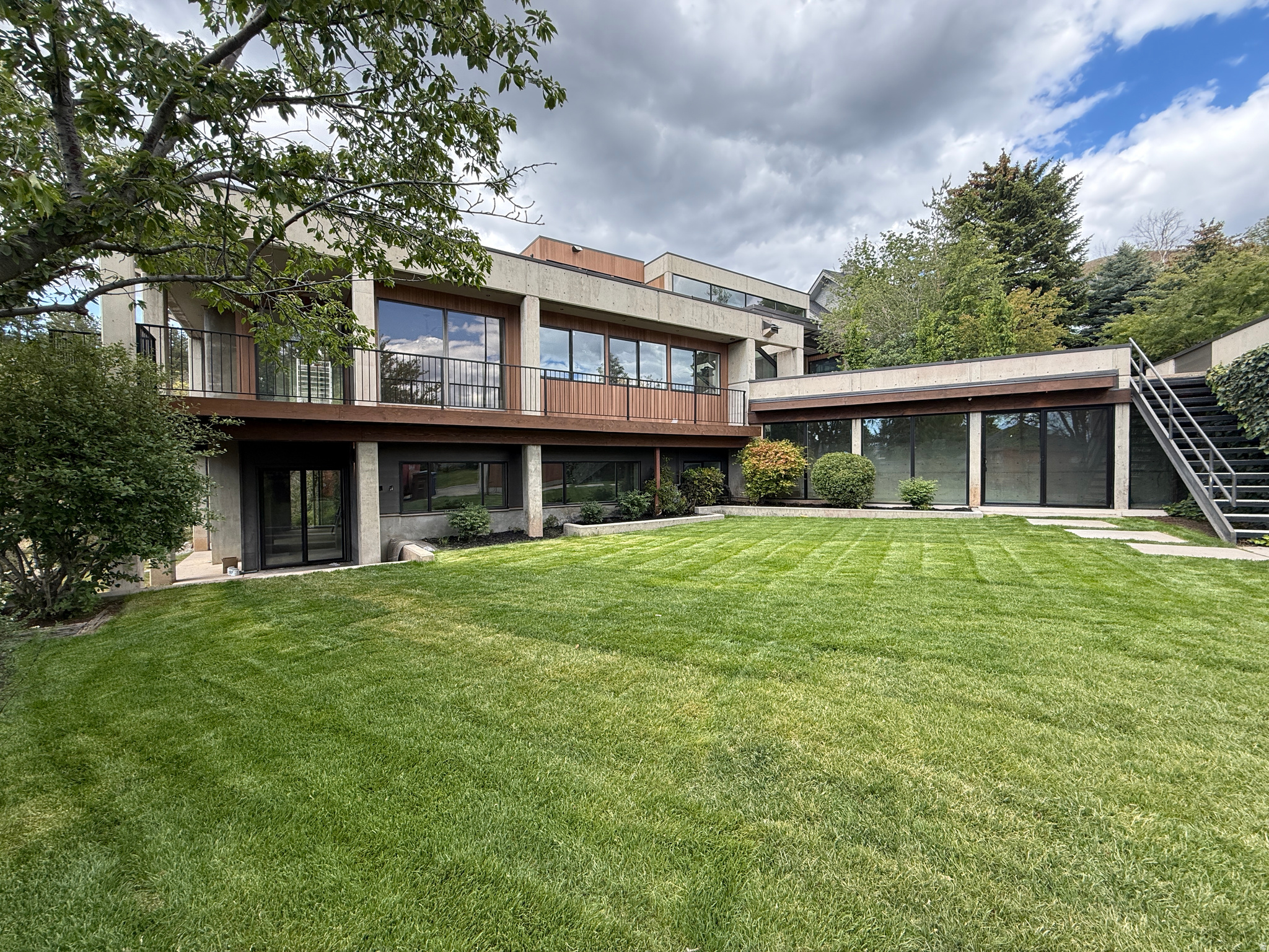 Perched on a breathtaking mountainside lot in Federal Heights, this stunning contemporary home designed by W.N. Cooper makes a bold architectural statement. The striking blend of concrete, soaring glass walls, warm wood accents, and organic finishes such as natural stone and plaster, create a home that feels both dramatic while also feeling warm and inviting. Tucked away in a quiet .68 acre cul-de-sac lot backing the wooded Dry Creek Canyon, the setting offers peaceful mountain views while simultaneously offering incredible city views of downtown Salt lake City and the Capitol.  The spacious primary suite offers its own secluded escape with an en suite bath surrounded by a running water feature that makes it feel and sound like your own personal indoor/outdoor retreat. With serene outdoor access this primary suite is designed to immerse you in the surrounding nature.  Each of the three additional bedrooms includes its own attached bathroom, offering comfort and privacy throughout. The fifth bedroom can be used as a bedroom or is currently designed for use as an office.  The upper level of the home has 360 views with windows in every direction and multiple decks around the home capture every city and nature view. This is certainly a one of a kind home and a must see.  Square footage figures are provided as a courtesy estimate only and were obtained from independent measurement.  Buyer is advised to obtain an independent measurement. Buyer to verify all listing details.