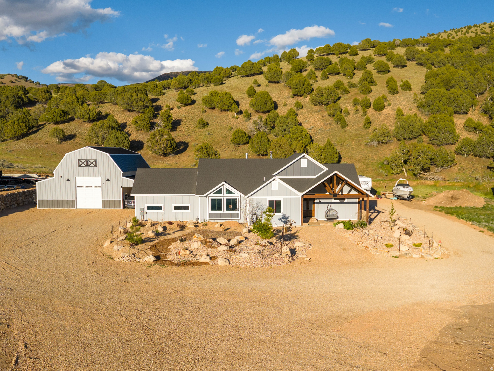 Welcome to Cottonwood Canyon, one of the best-kept secrets near Park City - where quiet mountain living, open space, and privacy create an unmatched lifestyle. Situated on 1.36 acres, this impeccably maintained 2023 custom-built estate offers luxury finishes, thoughtful upgrades, and exceptional functionality throughout. Inside, the home features soaring 17-foot vaulted ceilings in the living room, 10-foot ceilings throughout, custom 9-foot knotty alder doors, knotty alder trim and shutters, hickory hardwood flooring, stone accents, and designer lighting. The kitchen is a true centerpiece with an oversized leathered granite island, premium Forno appliances, a 48" 8-burner gas range with double ovens, pot filler, oversized farmhouse sink, and massive built-in refrigerator/freezer. Additional upgrades include soft water, upgraded privacy windows, security cameras with audio, 220 power, gas lines for BBQs, and two wood-burning stoves. The backyard borders approximately 80 acres of permanently protected land, creating peaceful evenings around the fire pit, on the oversized patio, or in the hot tub. Xeriscape landscaping, a sprinkler system, flower beds, garden space, irrigation hydrants, and a 20-foot fire barrier provide beauty with low-maintenance living. One full share of Hoytsville Irrigation Company water is included if additional landscaping or horse pasture is desired, and the culinary well water right is individually owned. The impressive 45'x55' heated shop includes its own septic, water, gas, power, LED lighting, pull-through 14-foot doors, RV dump, and endless possibilities for storage, hobbies, workspace, or ADU for long or short-term rental opportunities.