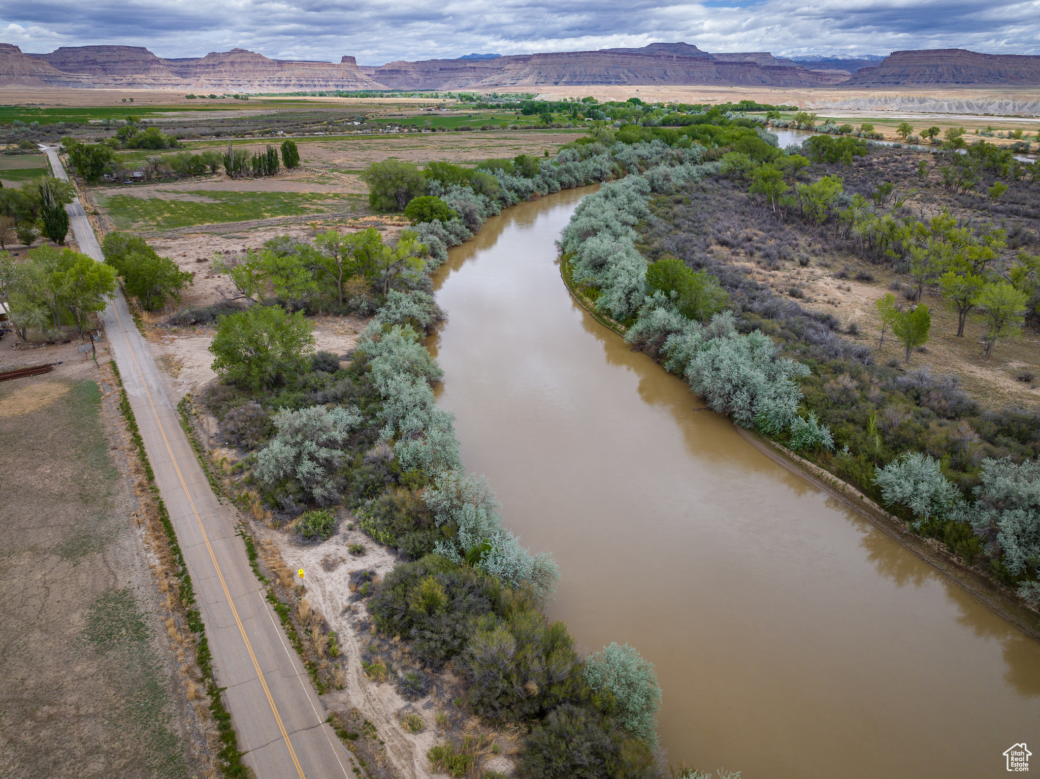 Desert Emerald | Along the Green River  Discover a rare stretch of agricultural land just minutes from Downtown Green River. Set against the dramatic backdrop of the Book Cliffs with the Green River running through it, this 11.96-acre parcel offers a unique mix of serenity and access. Whether you're dreaming of a private retreat, basecamp, or homestead, this property places you within an hour of world-class recreation-San Rafael Swell, Ruby Ranch Dunes, Goblin Valley, Canyonlands, Arches, the Colorado River, and Moab. Embrace wide-open skies, endless views, and the untapped potential of life along the river.
