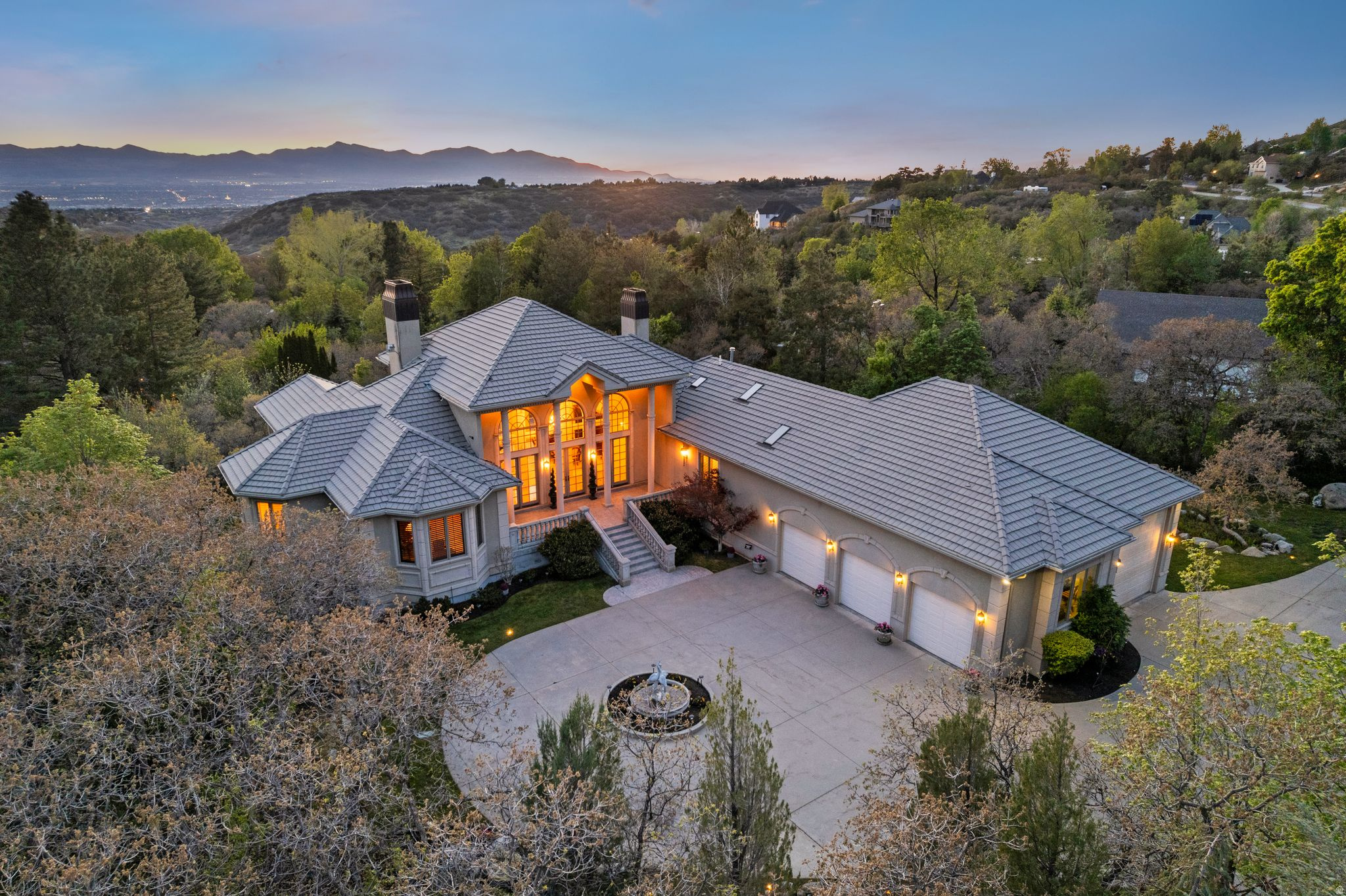 Tucked beneath the Wasatch Mountains in one of Sandy's most exclusive executive enclaves, this meticulously maintained estate offers a rare combination of scale, privacy, and timeless craftsmanship. Positioned on over an acre below iconic Wasatch Boulevard for a quieter, more secluded setting, the home spans over 8,000 square feet with soaring vaulted ceilings, maple flooring, extensive crown molding, plantation shutters, and grand entertaining spaces designed for both everyday living and large gatherings. The winged floor plan offers exceptional functionality with a luxurious primary retreat featuring a sitting area, private deck access, multiple walk-in closets, and a spa-inspired bath, while the expansive kitchen and living spaces anchor the heart of the home. A dramatic wall of windows frame breathtaking views of the surrounding mountains and fills the home with natural light. Outside, mature grounds, tranquil water features, and multiple outdoor living areas create a true private retreat. Significant updates include newer stucco, high-efficiency HVAC systems, two new water heaters, water softener, and a durable 50-year barrel tile roof. The heated 5-car garage is equally impressive, accommodating a 40-foot RV complete with 50-amp service and waste hookup. With approximately 4,300 square feet of unfinished space still available for future expansion, this estate offers an extraordinary opportunity to create a lasting legacy property for generations to come. The unfinished basement does have electrical run, plumbing stubbed, and all HVAC ductwork installed under the slab and functional which is a huge premium.
