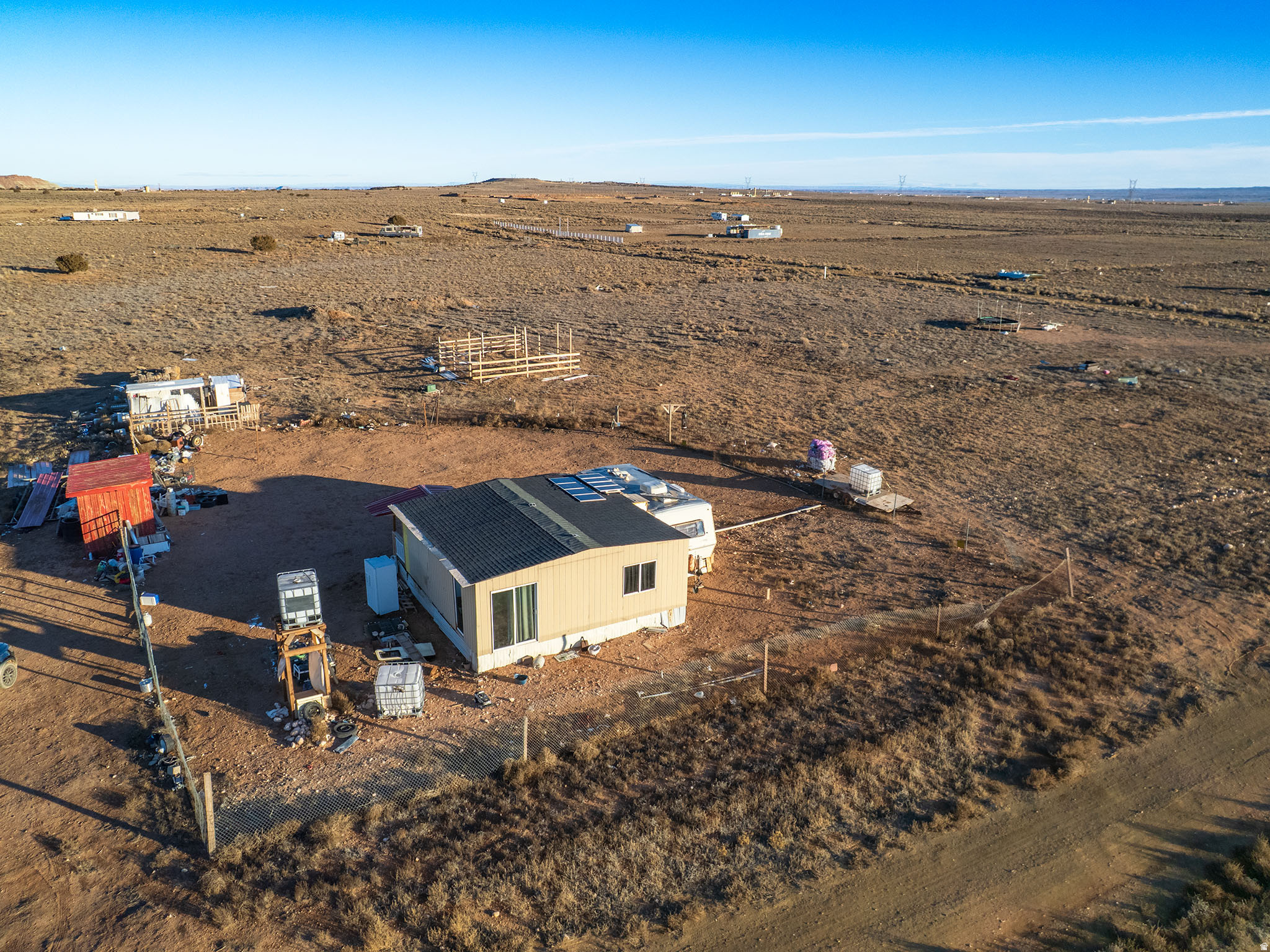 North of Duchesne about 7 miles and then east.  This is an off grid, family built cabin that has a living room, kitchen, and bedroom.  It has a front door and a side door.  The side door opens into a nice camp trailer for a bathroom and another kitchen.  It is on solar.  You must come into town to get water and take it back to the property.  Please ask us.  It has a great fence for your livestock and pets!  And a great shed/chicken coop.  It is flat, buildable, and has an unobstructed view of the Uintahs and the Wasatch Mountains!  Miles of back roads for exploring!  Seller is anxious to sell.  Come on out and see!