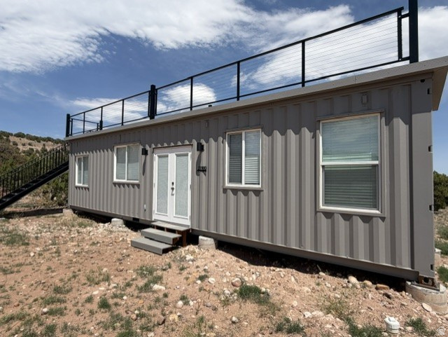 Escape to your own private retreat in the Cedars on 8 Acres! This unique tiny container home is tucked away in a secluded setting surrounded by nature and offers incredible views in every direction. Enjoy your morning coffee or evening sunsets from the rooftop deck while taking in the breathtaking scenery. Whether you're looking for a peaceful getaway, vacation rental opportunity, or minimalist lifestyle, this one-of-a-kind property delivers privacy, tranquility, and views for days.  Square footage figures are provided as a courtesy estimate only and were obtained from Seller.  Buyer is advised to obtain an independent measurement.