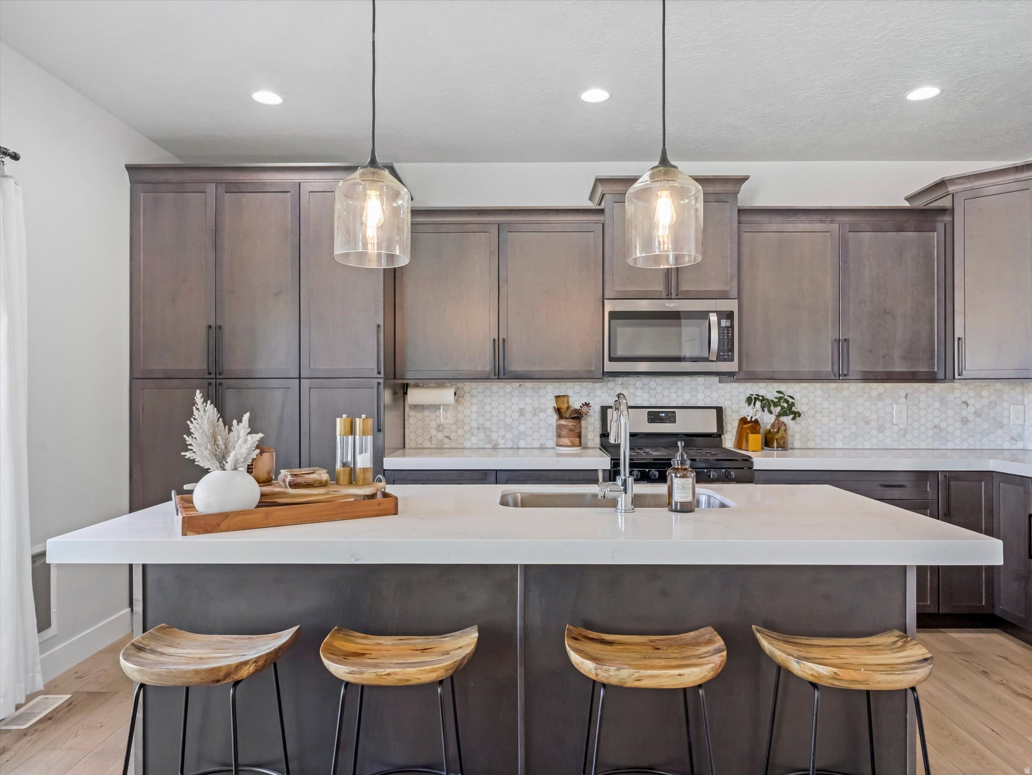 It's the 4th of July, your friends are over, the grill is going, and the FIREWORKS are lighting up the sky and YOU get the BEST view. When the Builder offered upgrades, they said "YES" to all of it!! Come see for yourself why this 2021 townhome in the desirable Villages at 27th is so special.  This light-filled home features vaulted ceilings, oversized windows, quartz countertops, a marble backsplash, shaker maple cabinetry, stainless steel appliances, a gas range, and an upgraded extra-long kitchen island. The spacious primary suite offers vaulted ceilings, a walk-in closet, dual sinks, flex space, and an extended cultured marble shower. Premium carpet padding, an open stair railing, additional recessed lighting, and upgraded flooring. The unfinished basement is roughed for plumbing and ready for future expansion. Enjoy a covered patio, open space behind the home (no backyard neighbors), a Ring security system, fiber internet wiring, and extra storage space in the 2-car garage. Large common green space complete with covered picnic tables and a playground. Conveniently located just minutes from I-15 and I-215 with easy access to shopping, dining, downtown, and the mountains.  HOA currently does not have a rental cap, but HOA Board is discussing one. Another owner is renting out their basement for $1100.00 a month. Come see why this is such a GREAT opportunity that will not last.