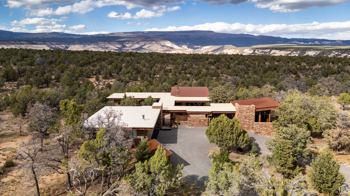 On Black Boulder Mesa, one of the most beautiful and inspiring places in Southern Utah, this classy custom home graces its place on the Mesa impeccably.  It is designed to follow the desire of the owners, as well as the spirit of the CC&R's, with appreciation of the spectacular Colorado Plateau views, the use of stone, glass and wood as exterior building materials and a seamless merging with its nature environment.  Privacy is a key element of life on the Mesa. This lot has an entire 45 acres, guaranteeing a sense of wilderness and solitude. All the homes on the Mesa cannot be seen from one another or the roads. The driveway for this home winds around tall pinion and juniper, leading to the intriguing entrance to the buildings. There are three separate structures joined by covered walkways. The garage is in the front, shielding the home while the guest home is on the other side. The home is toward the rear and accessed by a circular drive. The patios and walkways are all convenient and inviting, as well as contributing to a very pleasant outdoors.  There is an appealing wholeness and unity to the entire property. In addition, there is the benefit of the incredible night skies to give an appreciation of our planet and universe, The home is a very intimate, window-filled space with a comfortable great room, quality kitchen, guest bath, and master bedroom with an adjoining long vanity, leading to a tub and luxurious steam shower. It is a welcome place to return to after a day of hiking and exploring and represents a restorative refuge, both calming and invigorating. The plentiful, high-end windows serve to bring the outdoors inside, so that the transition between the two is less apparent.  Guests will appreciate the comfort and privacy of the guest house. The design and materials are comparable to the main house, with all the accessories for a pleasurable visit.  The location of the detached garage is ideal. It is generously sized to provide vehicles, bicycles and plenty of storage.  Because all of the buildings are covered in stone and surrounded by a xeriscape landscape with native plants and pinion and juniper nearby, the home is relatively maintenance free. The water is from a community well maintained by a water association with each owner having their own private water right. There is fiber for internet, cell service and all the connections to the rest of the world if required.  Between the extremely creative and functioning design of Black Boulder Mesa itself, and the successful innovative conception of the home, guest house and garage, together with an enormous 45 acres, the property is aesthetically pleasing, efficient and a wonderful place to be. The colors, shapes, textures and immensity of the landscape contribute to the rarity of this land and home on the Mesa. Close to miles of public lands, canyons & mountains.