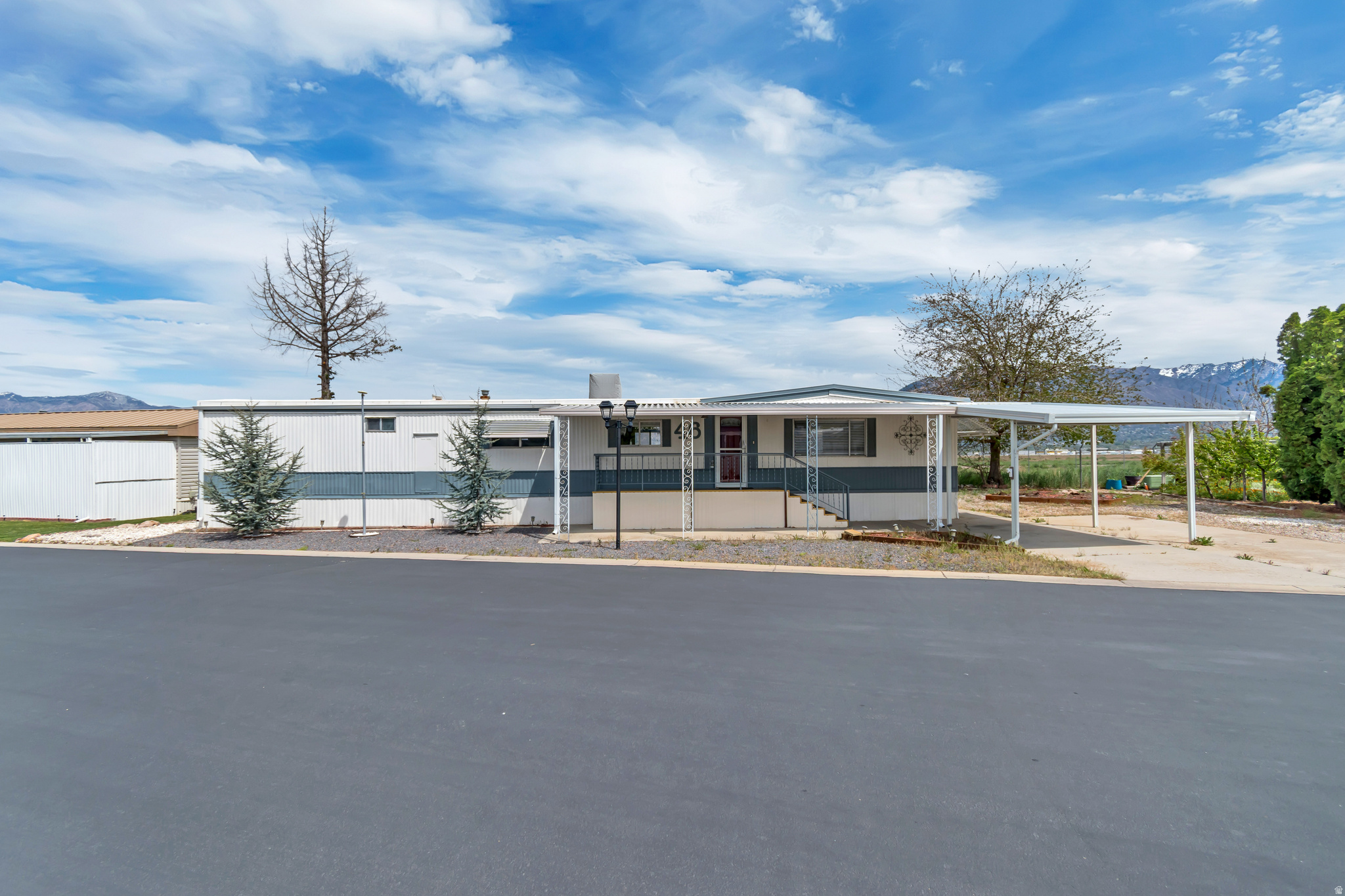 Beautifully maintained mobile home with no backyard neighbors, offering added privacy and open space. Ideally situated on the west side of the park with some of the best mountain views in the community. Enjoy relaxing on the spacious 30-foot covered deck surrounded by a private yard with mature trees. Interior features include vaulted ceilings and a comfortable layout.