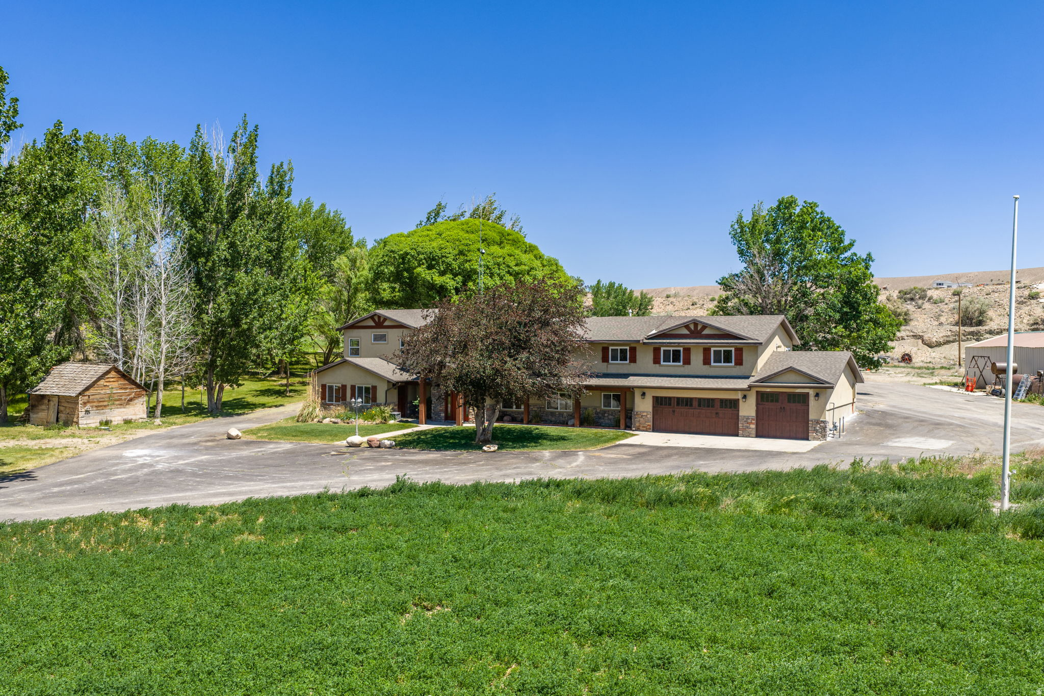 The perfect location & setting for a home! Property includes a tree-lined, paved driveway, shady yard and irrigation water. The irrigated pasture is fenced & perfect for livestock. Large pond fed by a natural spring, with paddle boat included. Multiple out-buildings include a large hay barn/equipment shed, old cinder block milk barn, metal sided shop/garage, sheds, and even a cabin! Home was updated several years ago with a large addition. The home is very spacious with multiple areas for entertaining guests, gourmet kitchen appliances, large offices, storage spaces and includes a natural gas back-up generator. Sale includes the smaller manufactured home at the south end of the driveway. That additional home has been a rental property for the owner.